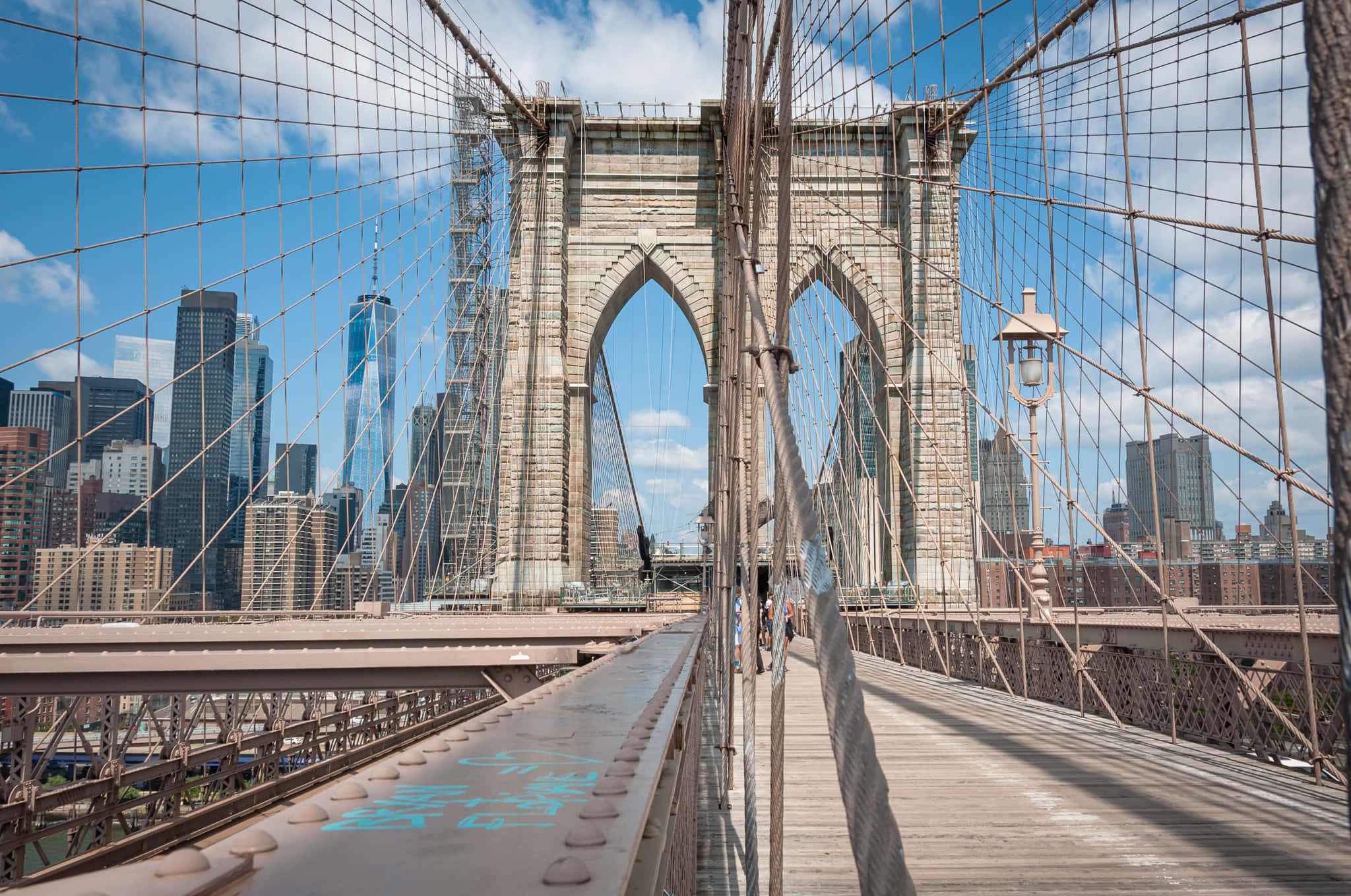 Nyc 桌布 壁紙 — 陽光明媚的白天景色，步行穿過布魯克林大橋，背景是紐約市天際線和藍天。