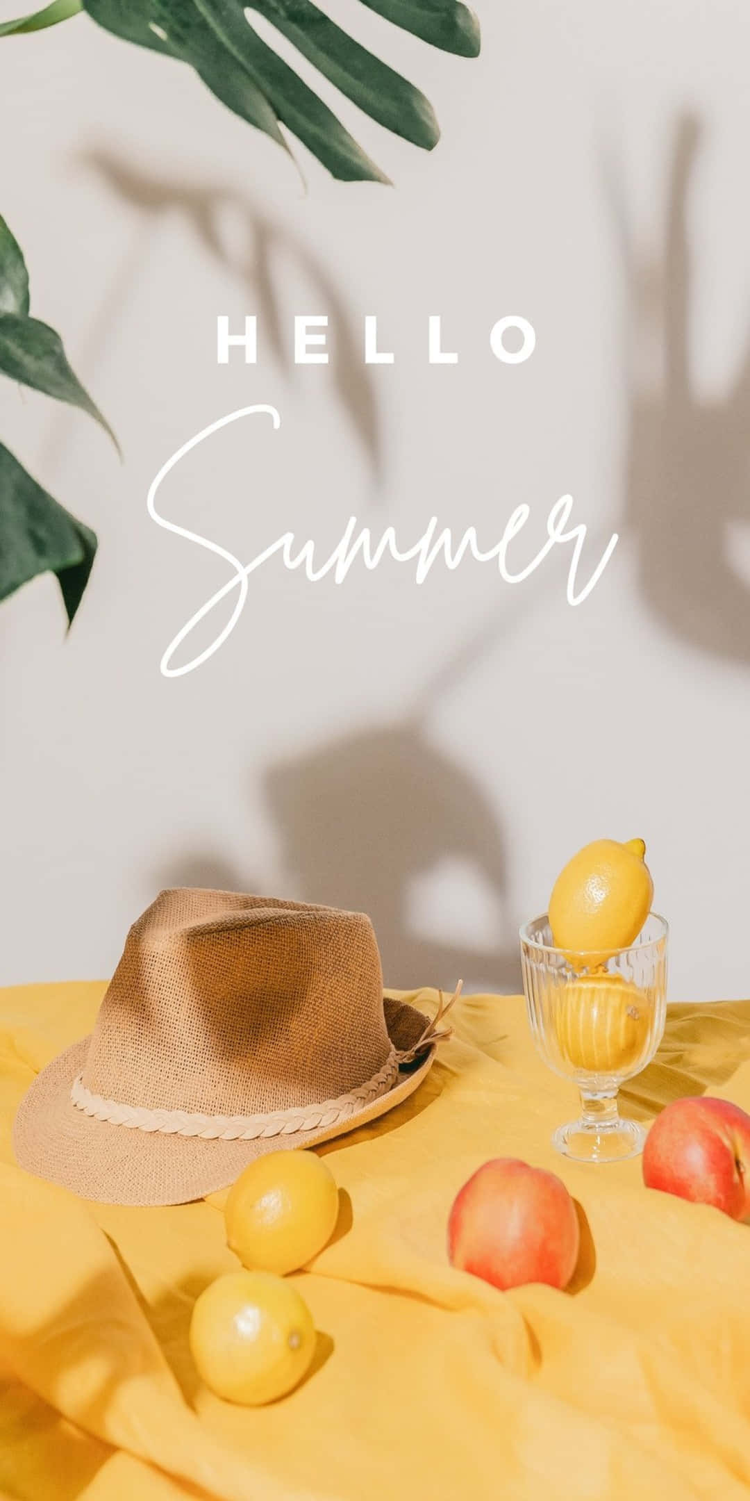 Pixel 3 Summer 桌布 壁紙 — 陽光普照的夏日場景，草帽、檸檬、桃子和龜背竹葉在黃色布上投下陰影。