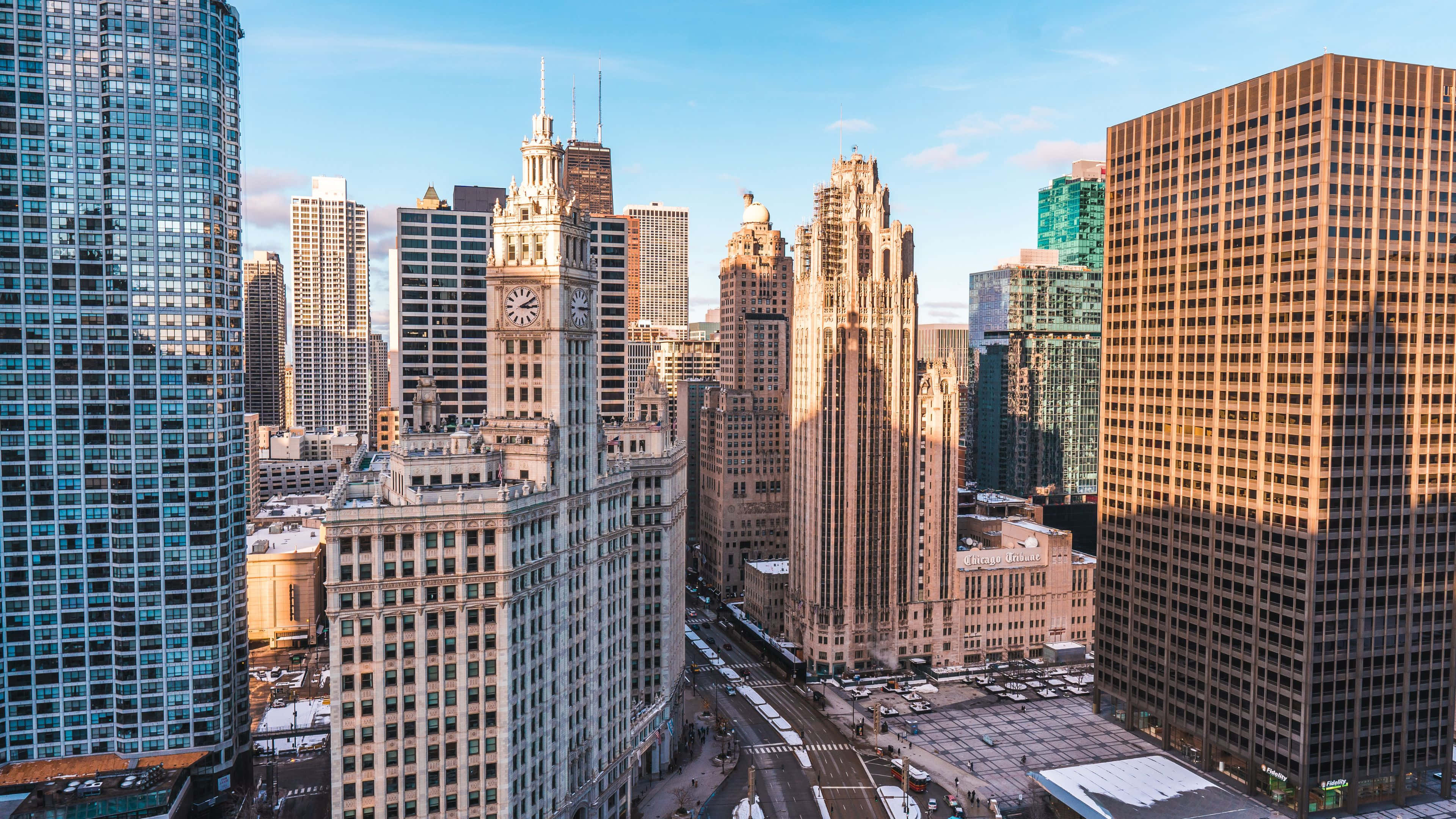 4K Ultra HD Chicago 桌布 壁紙 — 陽光灑落在高聳的摩天大樓和歷史建築上，在清澈的藍天下閃耀著金色的光芒。
