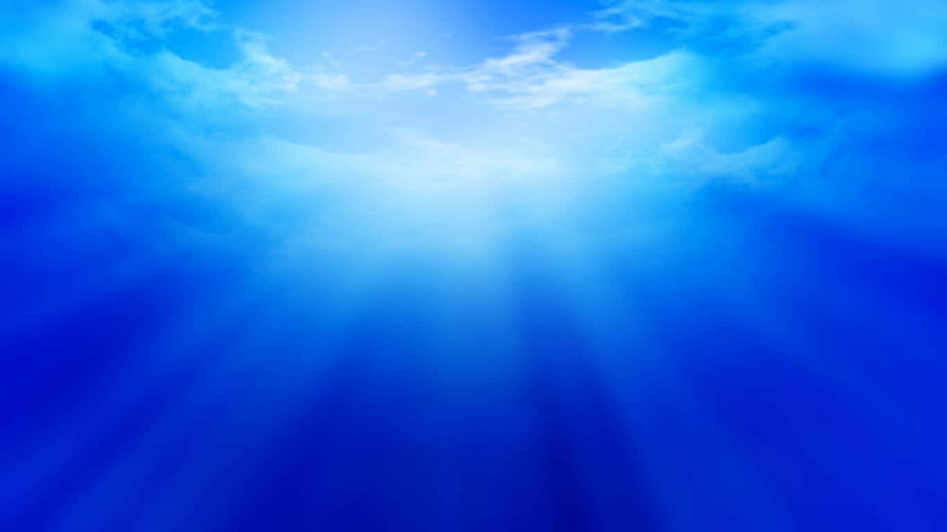  壁紙 — 陽光穿透廣闊的藍天，柔軟的白雲向下投射出耀眼的光芒。