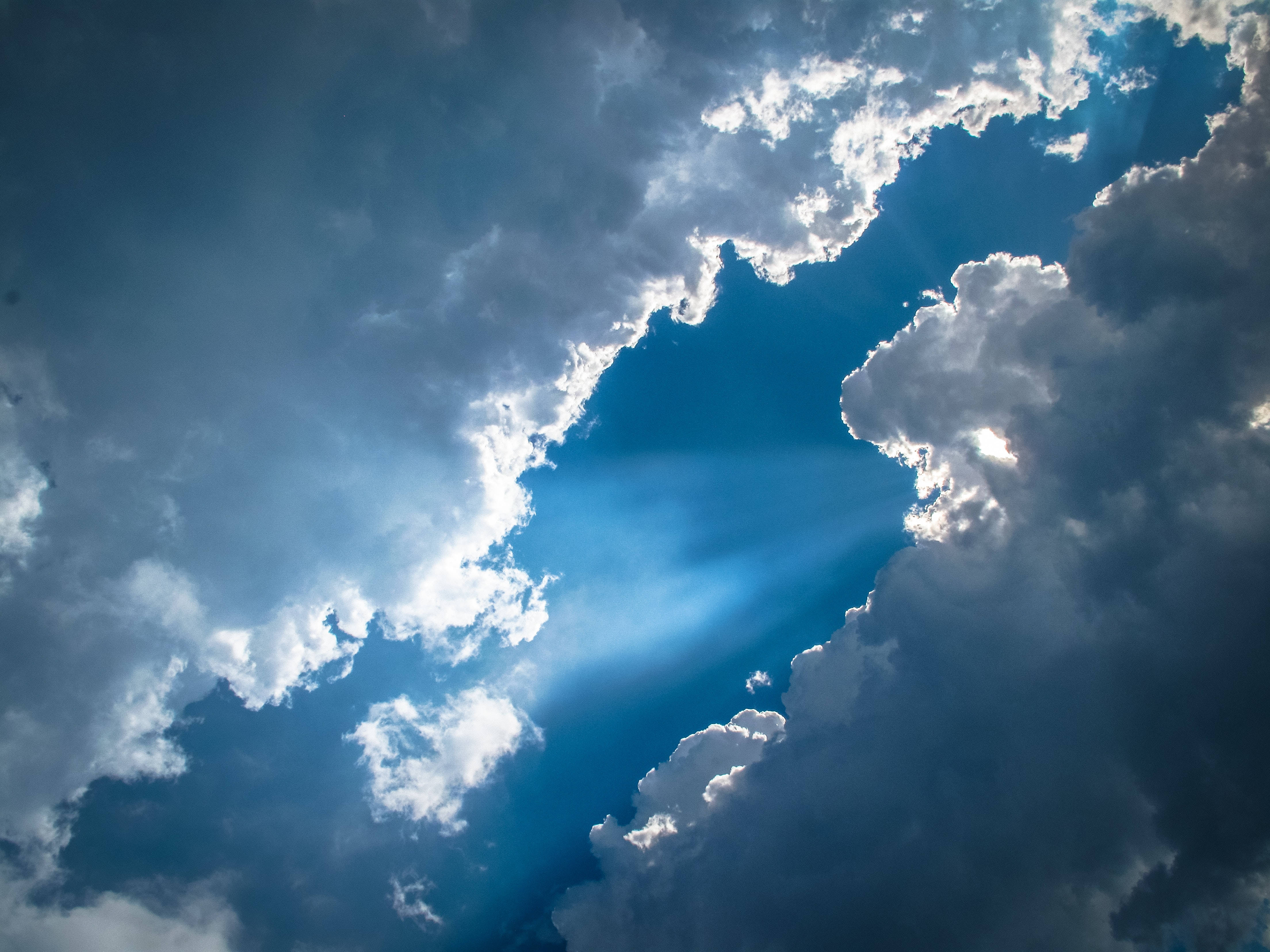 Light 桌布 壁紙 — 陽光穿透戲劇性的烏雲，映襯著充滿活力的藍天。