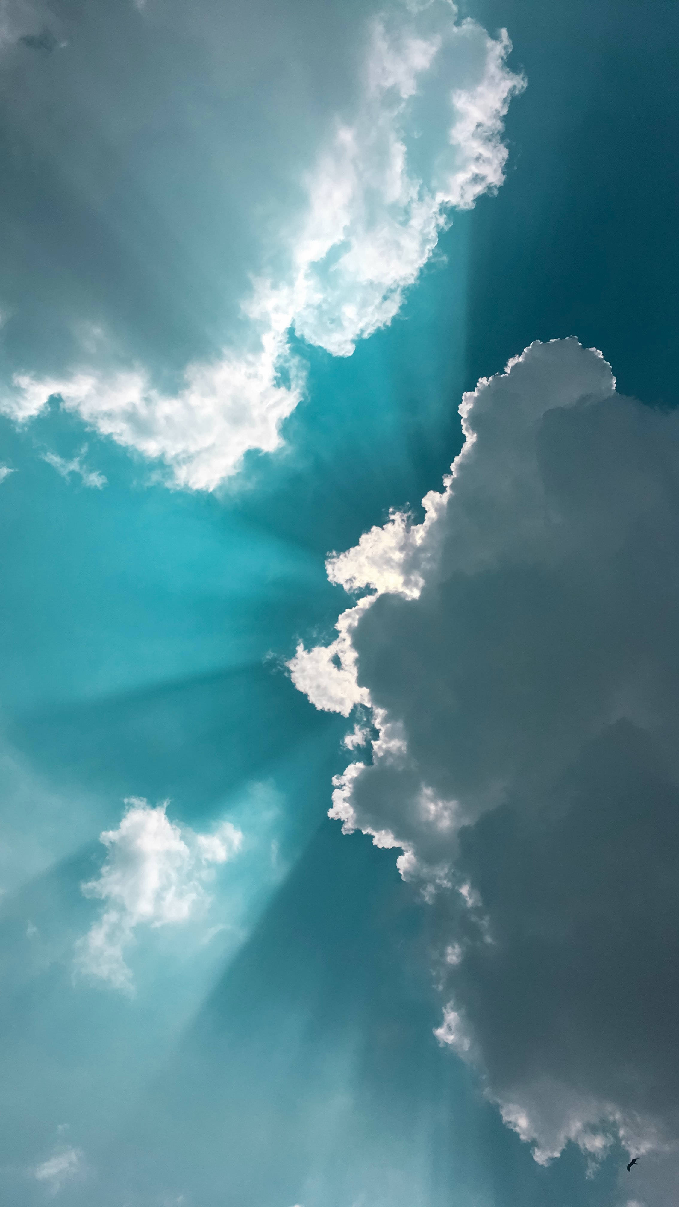 雲朵 桌布 壁紙 — 陽光穿透戲劇性的白雲，映襯著充滿活力的青綠色天空。