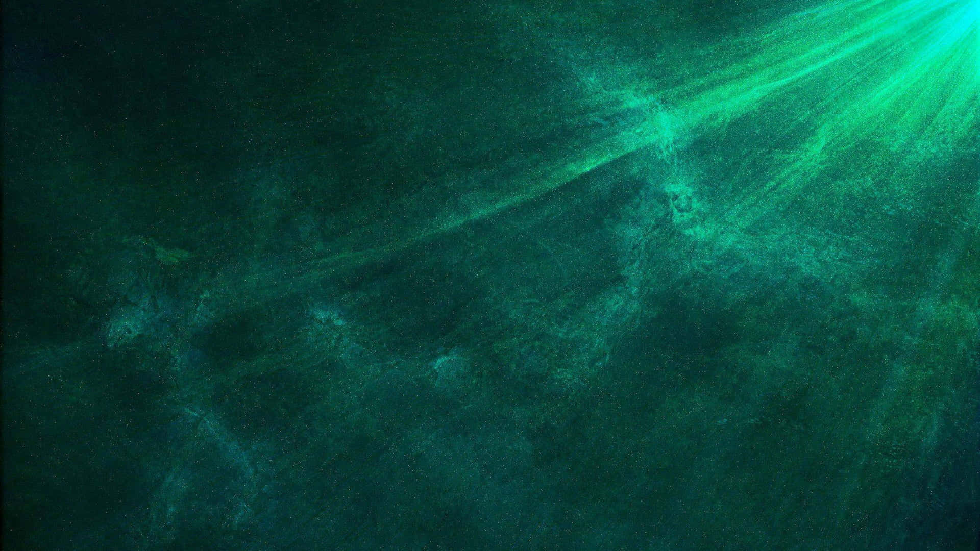 Dark Green Grunge 桌布 壁紙 — 陽光穿透深藍綠色海水，顯現出旋轉的微粒和微弱的水下紋理。