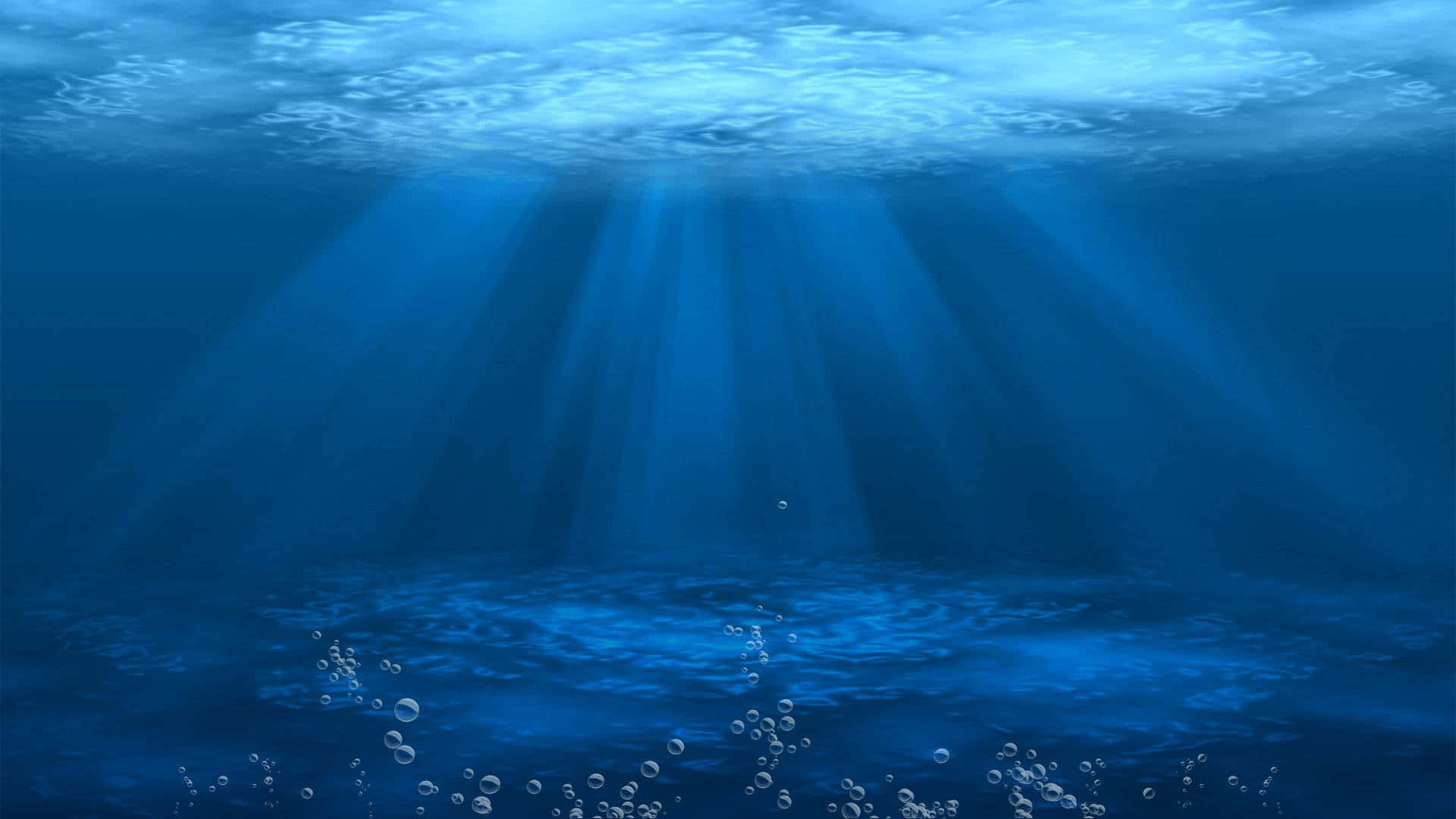 海洋 桌布 壁紙 — 陽光穿透深藍色海洋表面，照亮下方漂浮的氣泡。