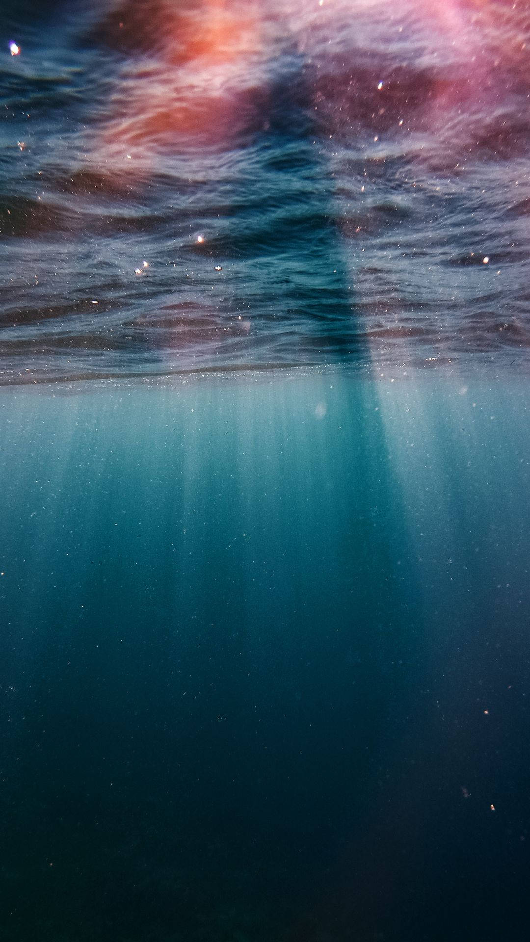 水 桌布 壁紙 — 陽光穿透漣漪的水面，在深藍色的水下場景中投射出空靈的光芒。