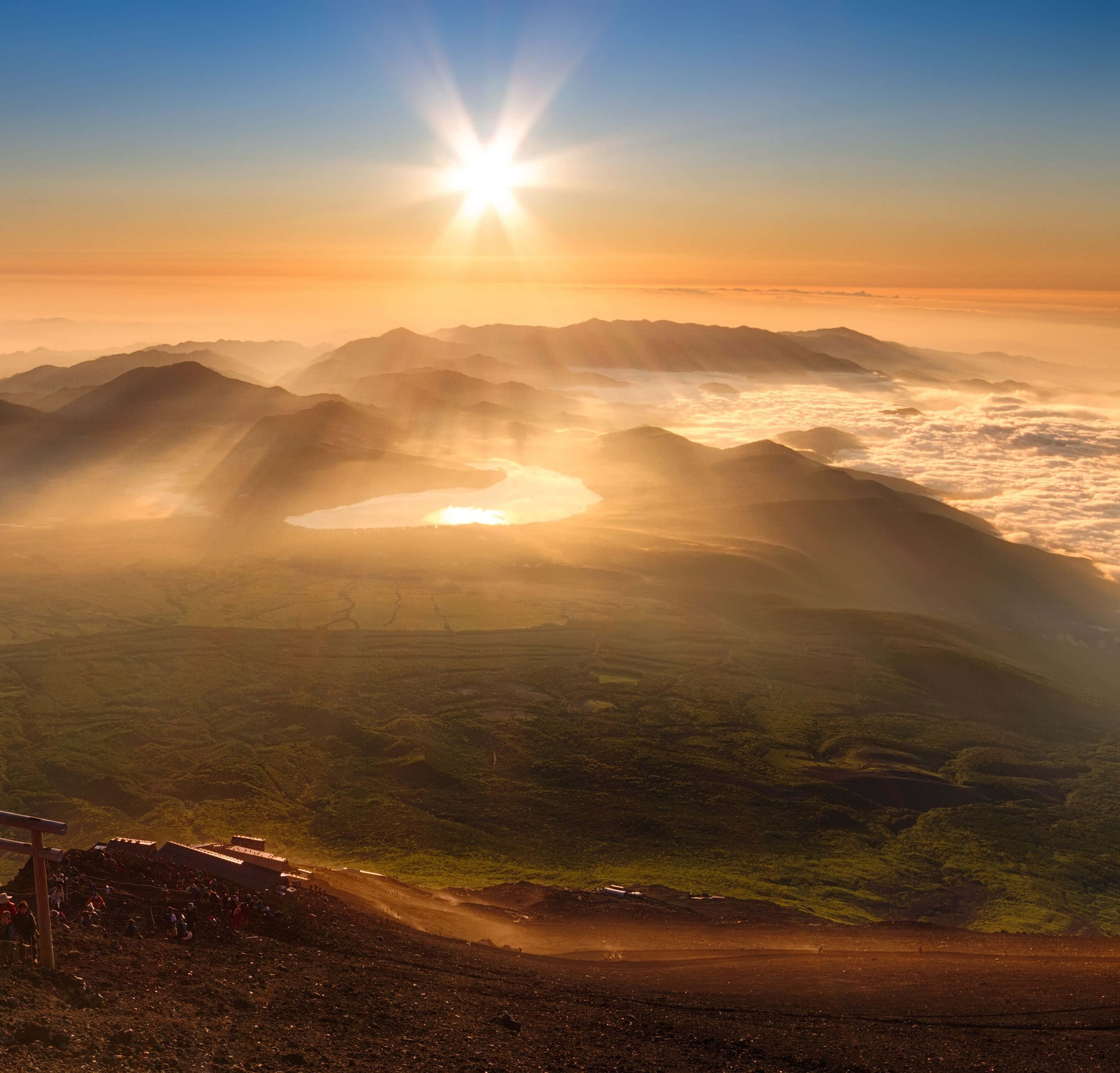 Hiking 桌布 壁紙 — 陽光穿透雲海之上霧氣籠罩的山峰，下方山谷中靜臥著一座寧靜的湖泊。