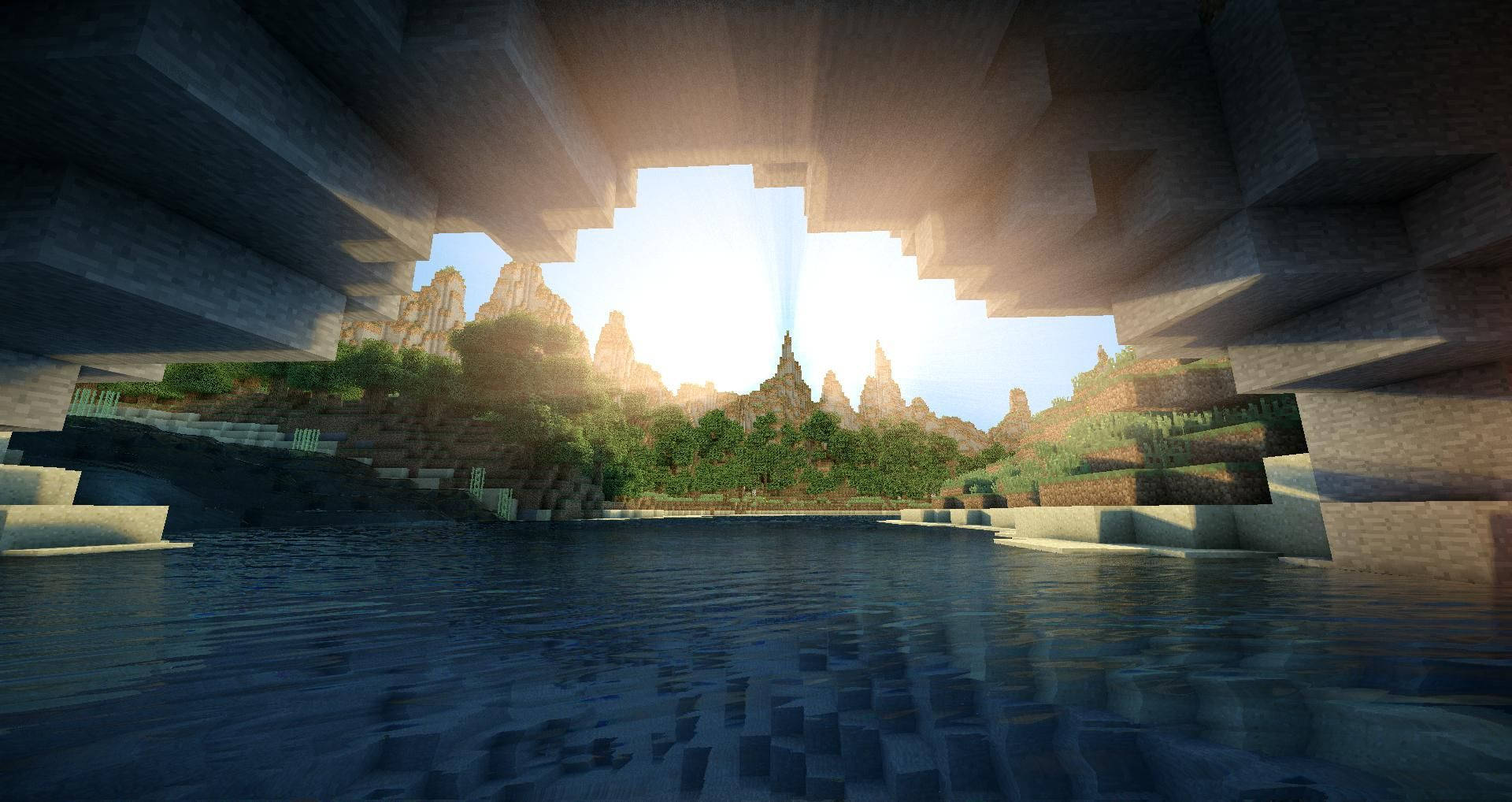 最佳我的世界 桌布 壁紙 — 陽光穿過 Minecraft 洞穴開口，照射到塊狀山景和下方平靜的水面。