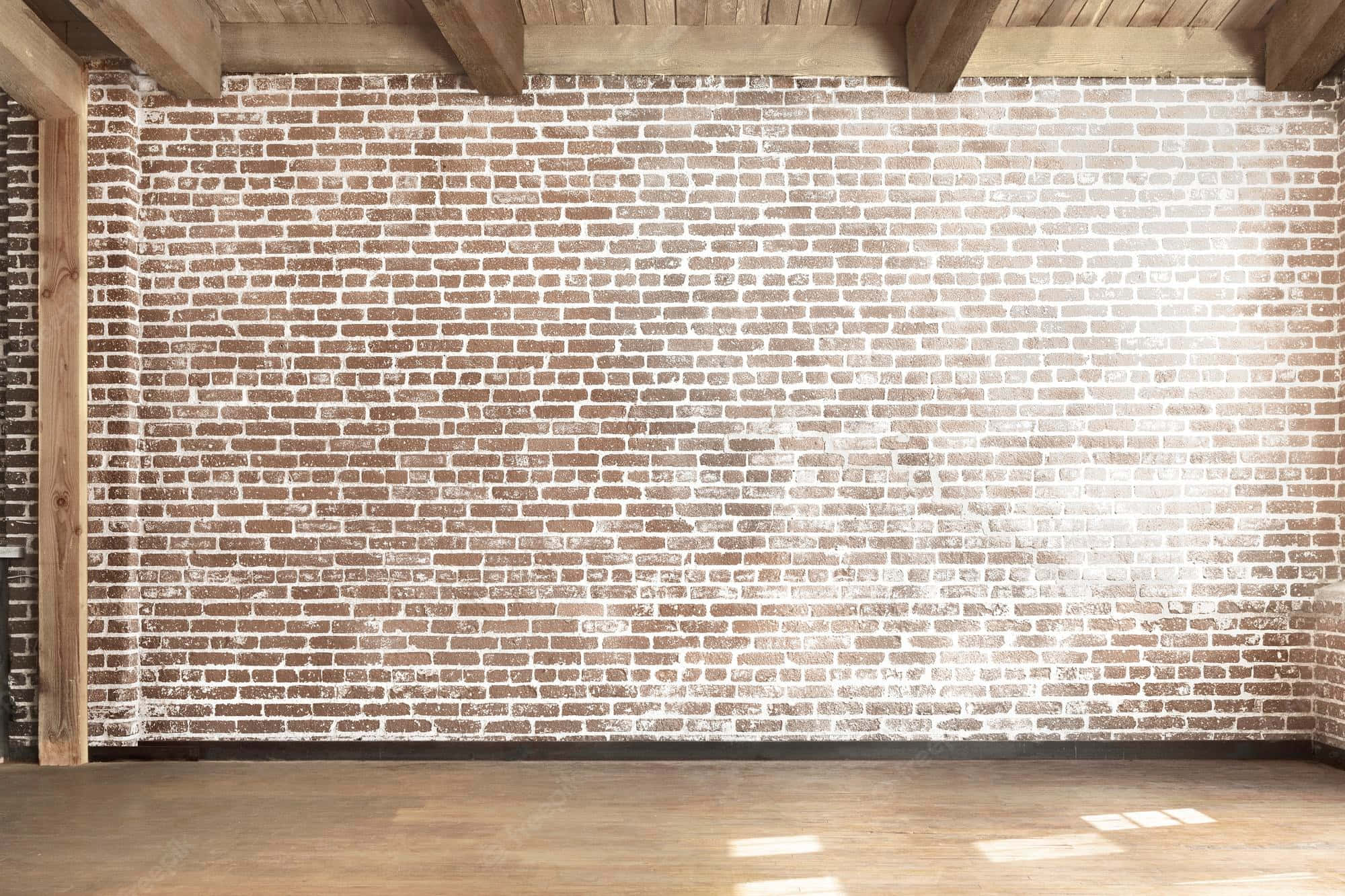 Brick Wall 桌布 壁紙 — 陽光穿過一個空曠的鄉村風格房間，照在風化的磚牆上，房間內有木樑和木地板。