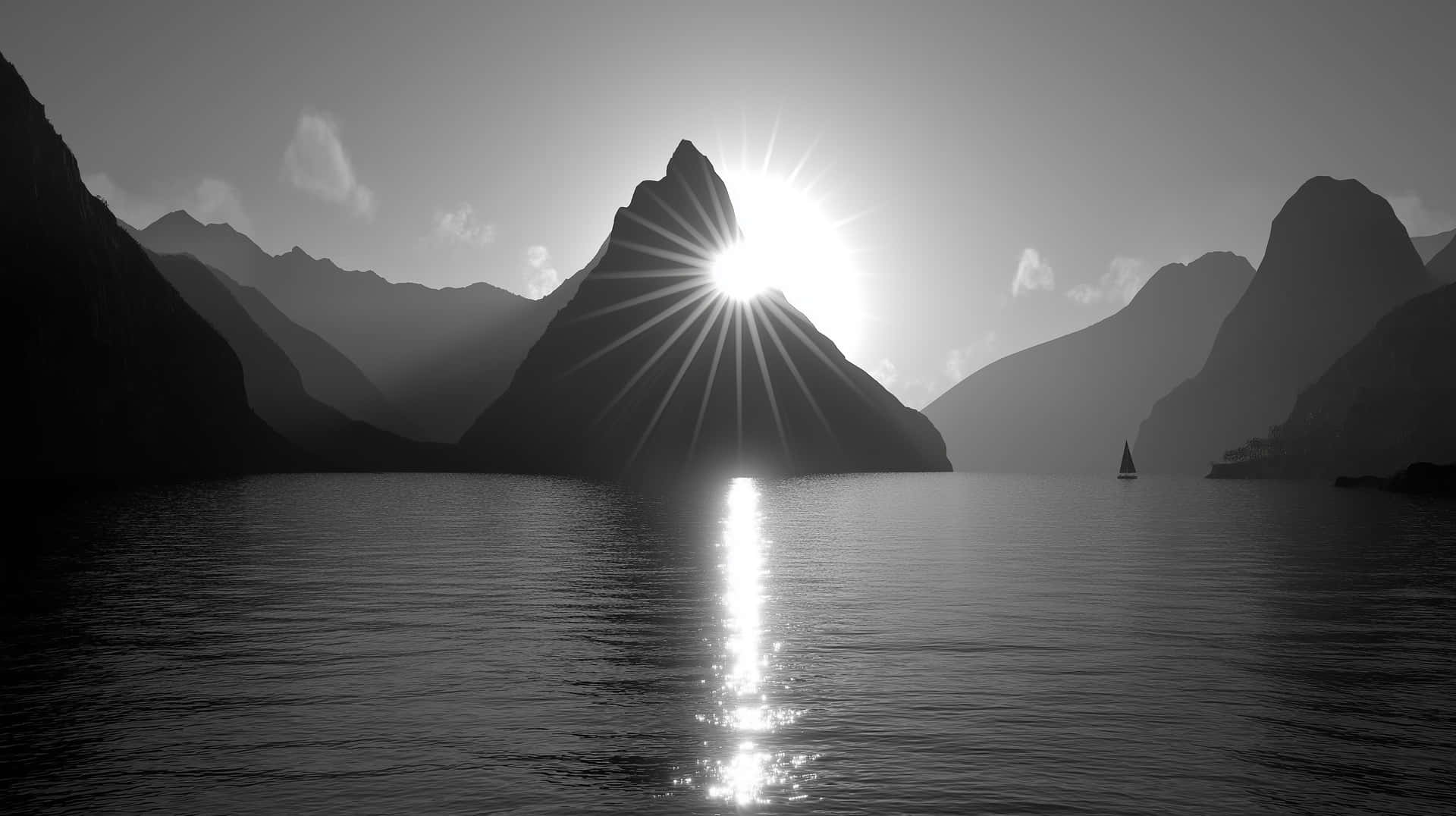 Mountain Peak with Sunrays Reflected on Tranquil Water 壁紙 — 陽光穿過山脈剪影，在平靜的水面上投射出燦爛的倒影，遠處有一艘孤獨的帆船。