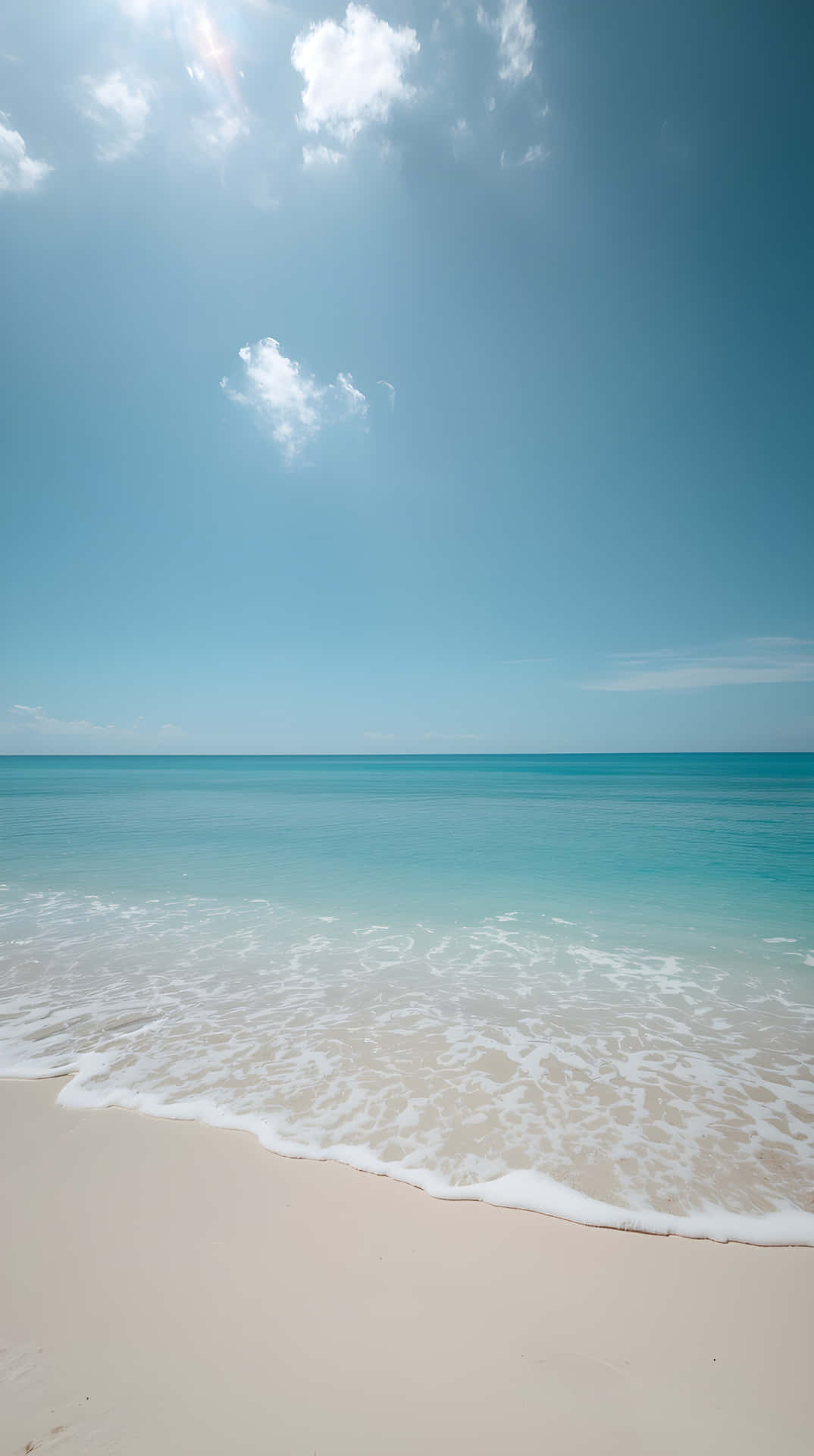 Crystal Clear Azure Sea Water Ripples on Sandy Beach 壁紙 — 陽光穿過散落的雲層，照射在平靜的碧綠海洋與柔軟的白沙相遇之處。