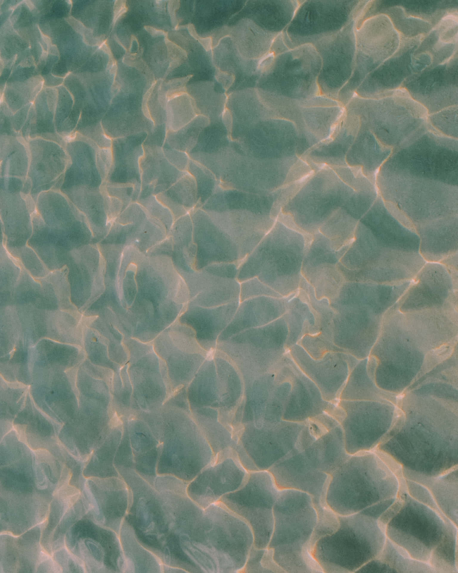 碧綠海水上的漣漪與金色陽光圖案