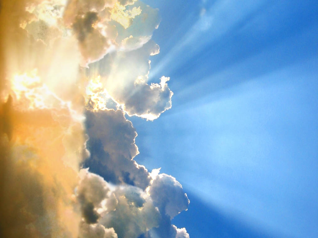 Heavenly Angels 桌布 壁紙 — 陽光穿過蓬鬆的白雲，映襯著充滿活力的藍天，形成戲劇性的金色光線。