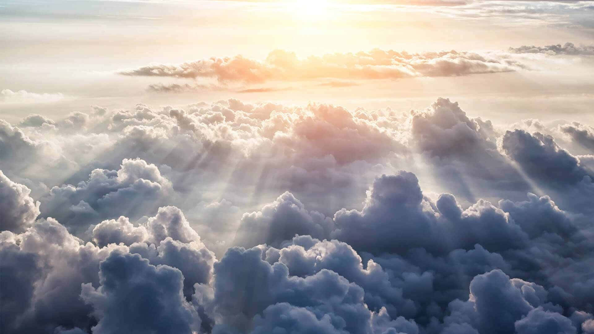 在寧靜的日出時分，陽光穿過蓬鬆的雲層照耀。 — 天堂 壁紙