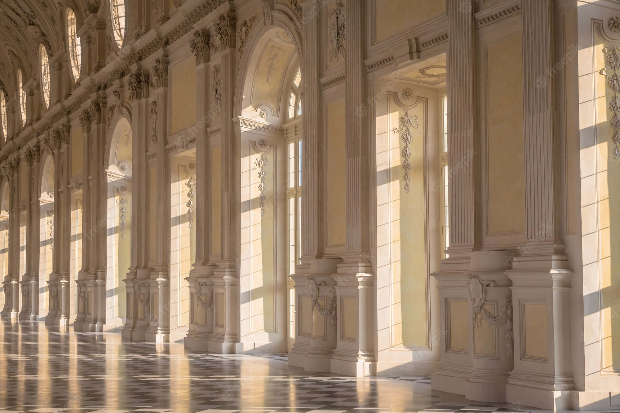 Italy Aesthetic 桌布 壁紙 — 陽光穿過高大的拱形窗戶，照亮了擁有大理石柱和棋盤格地板的大廳，華麗非凡。