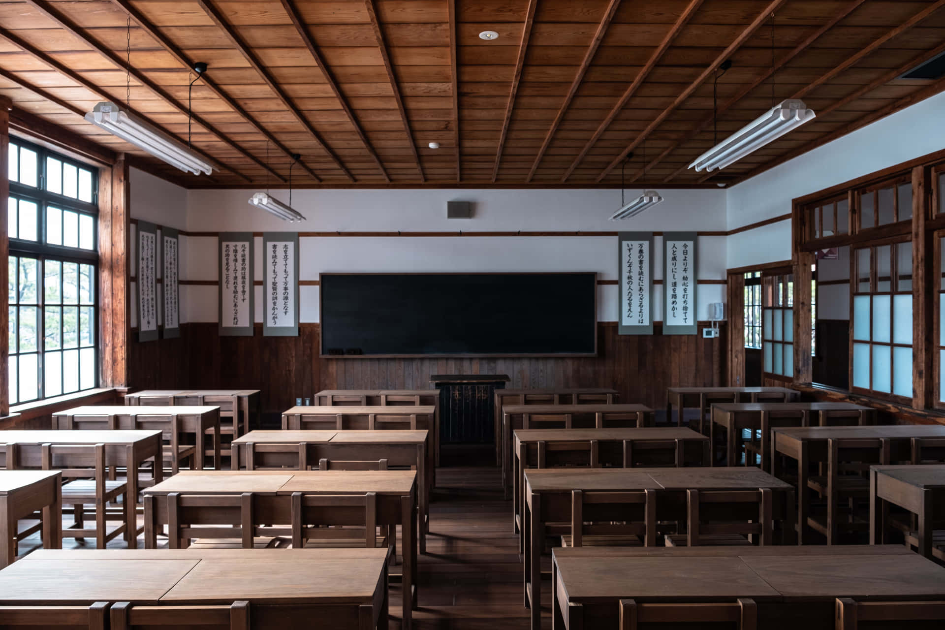 陽光照耀的傳統日本教室，有木桌和黑板。 — 學校 壁紙