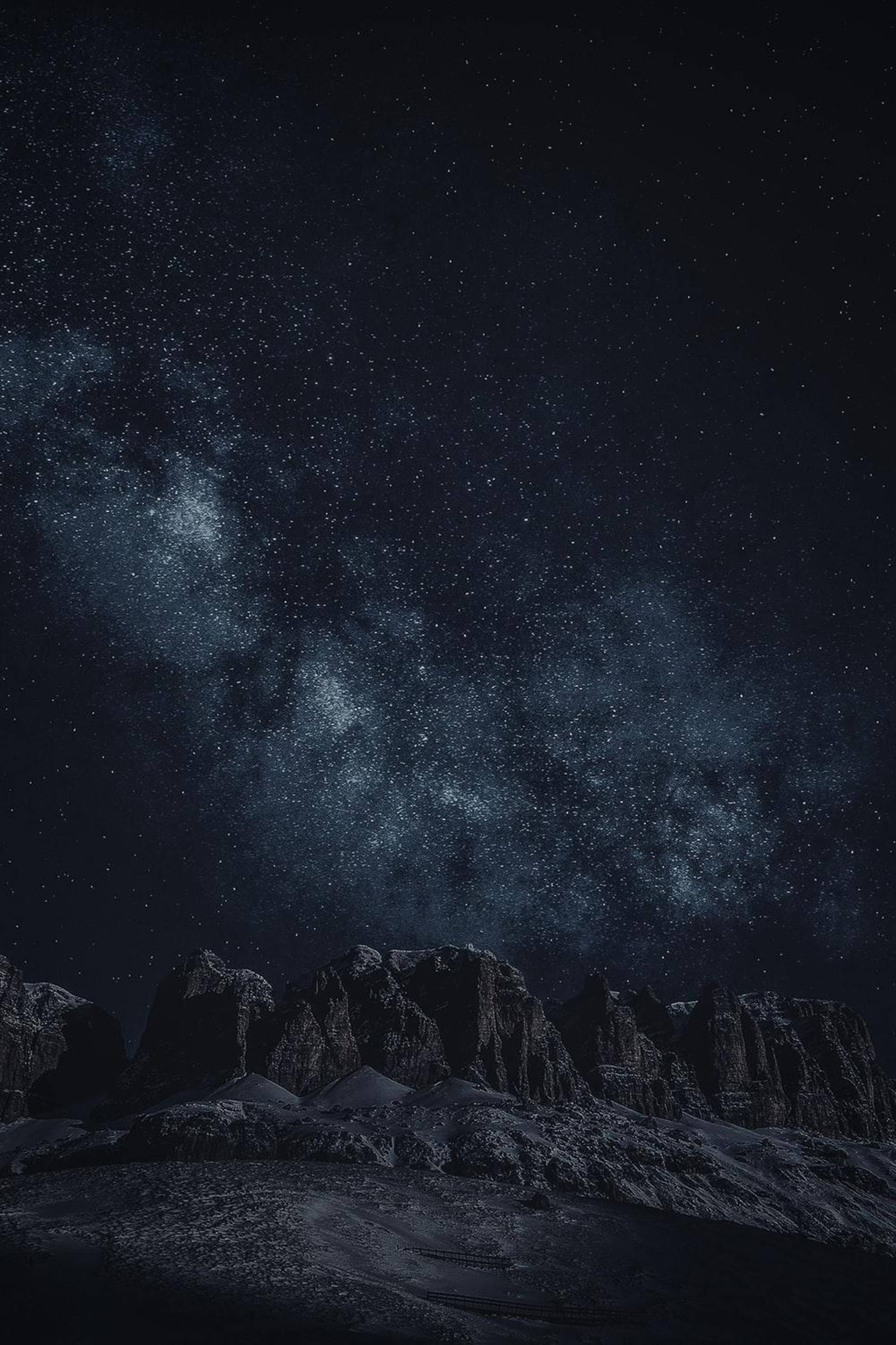 黑色 iPhone 桌布 桌布 壁紙 — 雄偉的山脈在繁星點點的夜空下，銀河在上方閃耀。