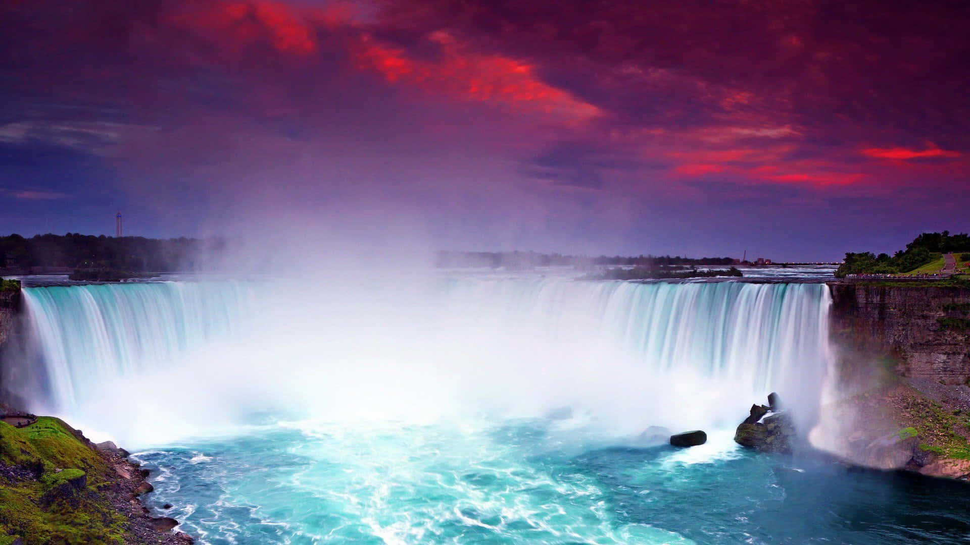 720p Niagara Falls 桌布 壁紙 — 雄偉的瀑布在戲劇性的紅色和紫色天空下傾瀉而下，薄霧從碧綠的水面升起。