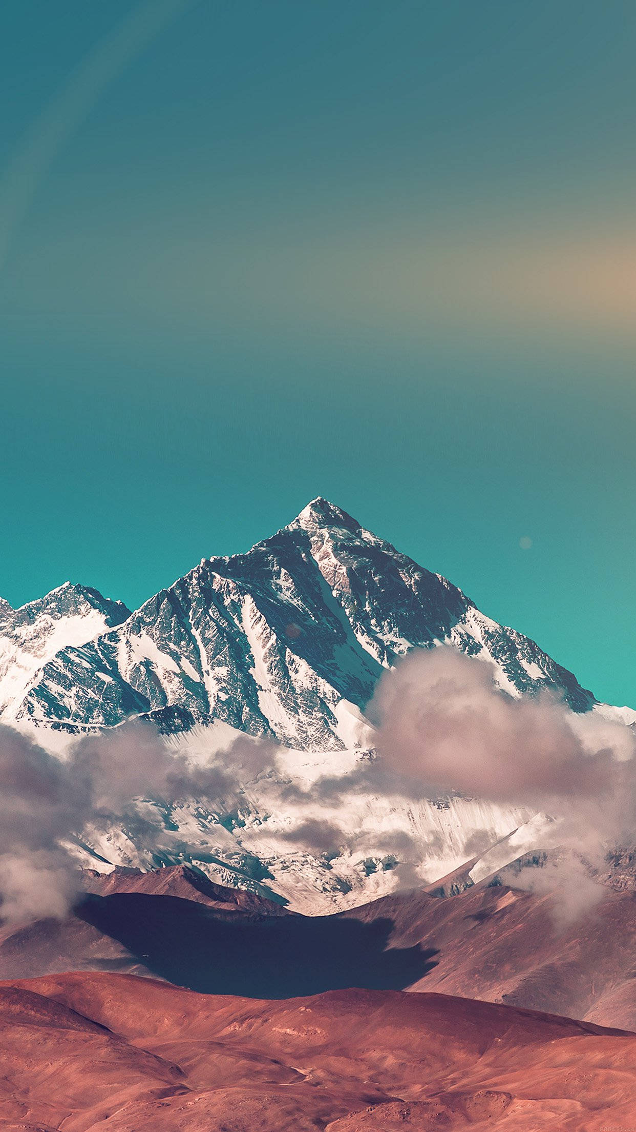Smartphone 桌布 壁紙 — 雄偉的雪山山峰刺穿充滿活力的藍綠色天空，上方是旋轉的雲層和微紅的沙漠地形。
