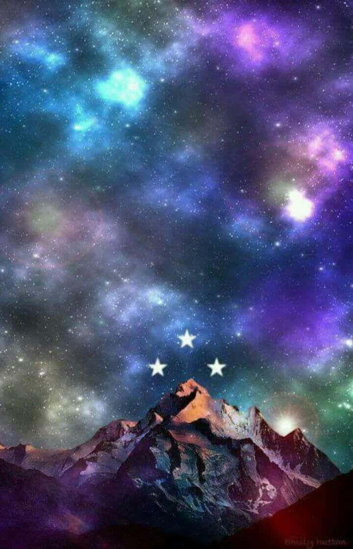 Starry Sky 桌布 壁紙 — 雄偉的雪山山峰在充滿旋轉星雲和閃爍星星的充滿活力的宇宙天空下升起。
