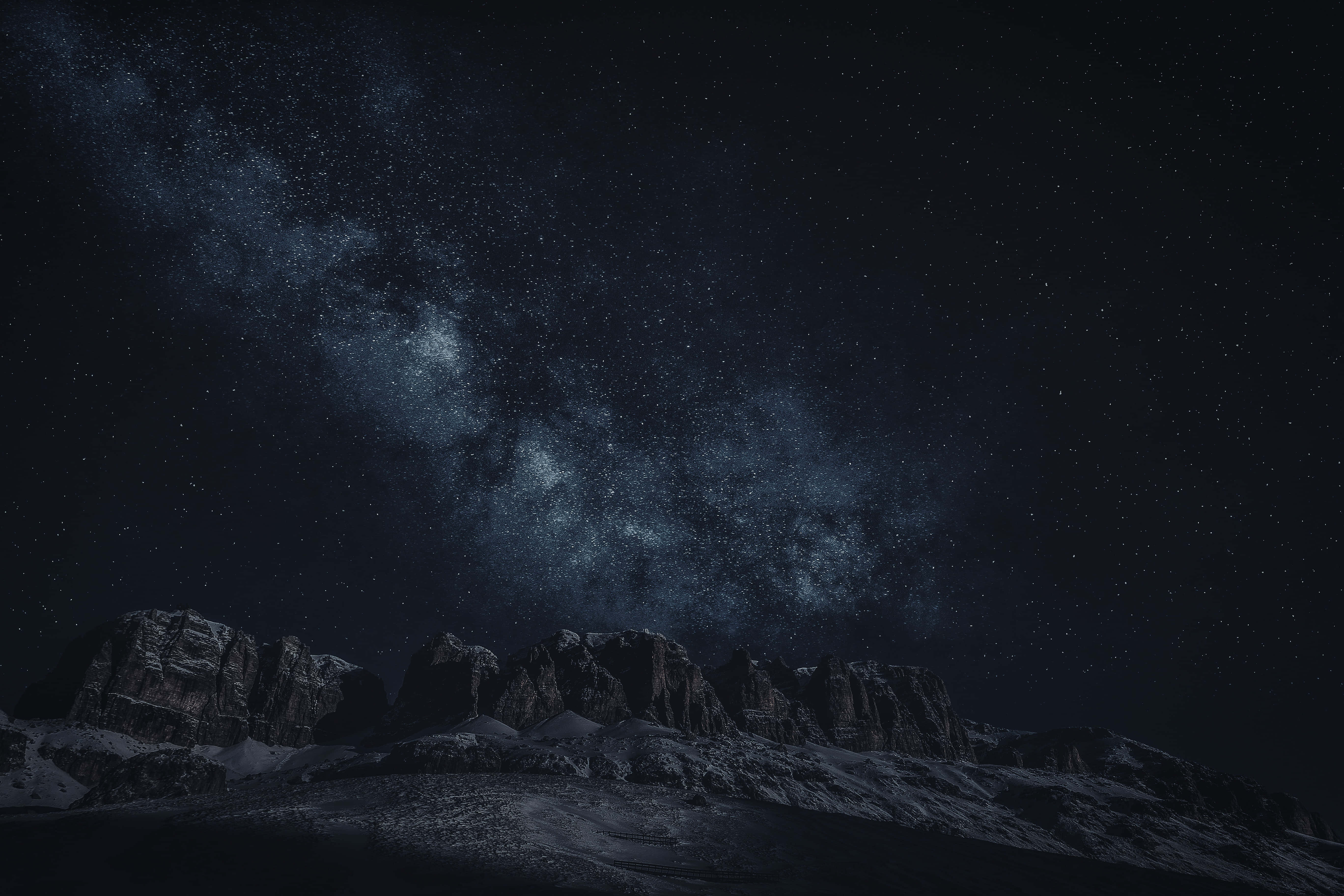 Stars 桌布 壁紙 — 雄偉的雪山山脈在令人嘆為觀止的星空夜空下呈現剪影，銀河在頭頂閃耀。