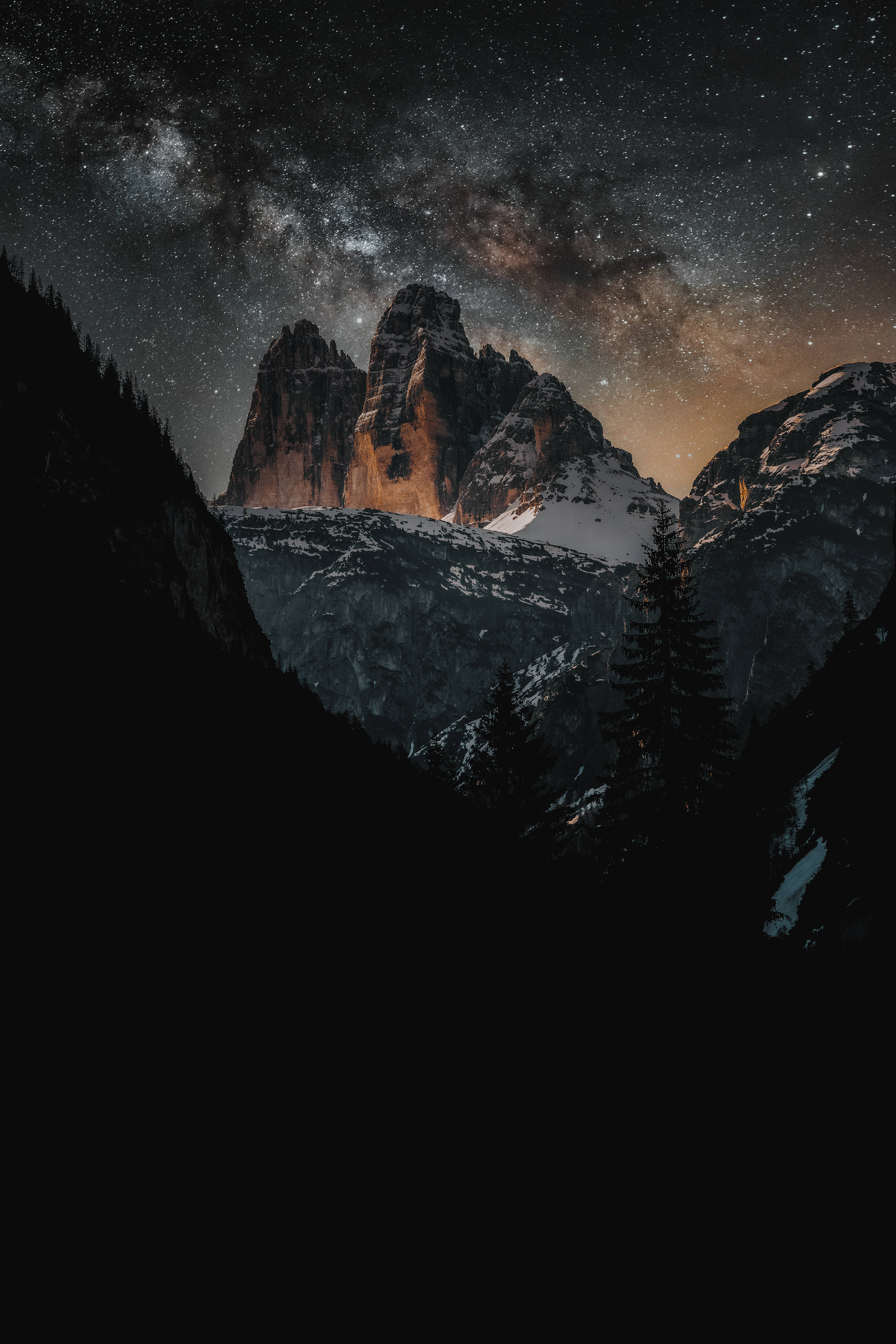Night Mountain 桌布 壁紙 — 雄偉的雪山山脈在燦爛星空下形成剪影，銀河拱橋橫跨天際。
