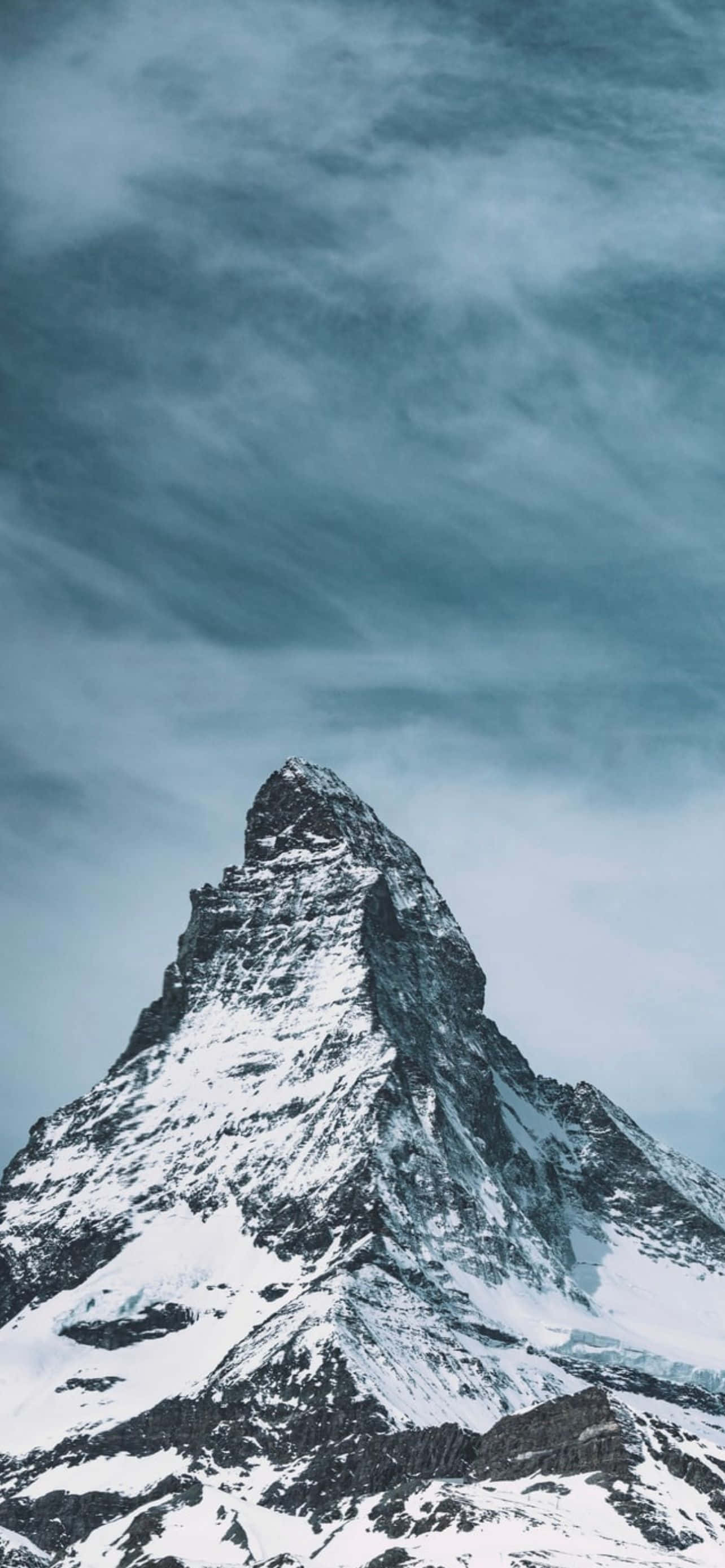 Mountain iPhone 桌布 壁紙 — 雄偉的雪山峰刺穿帶有漩渦雲層的憂鬱藍綠色天空。