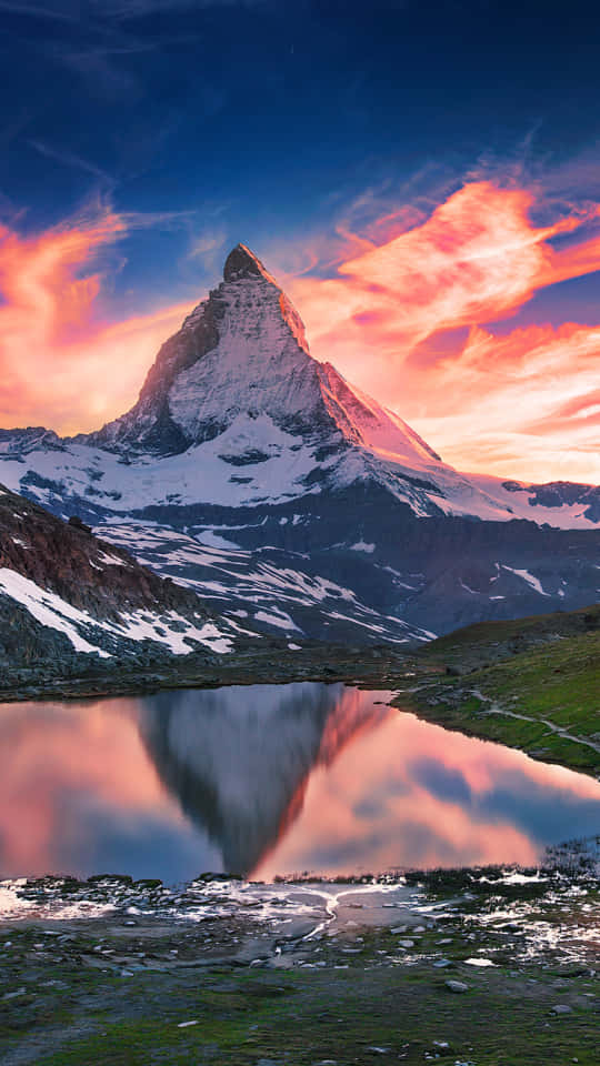 Mountain Aesthetic 桌布 壁紙 — 雄偉的雪山峰在充滿活力的日落天空下倒映在寧靜的高山湖泊中。