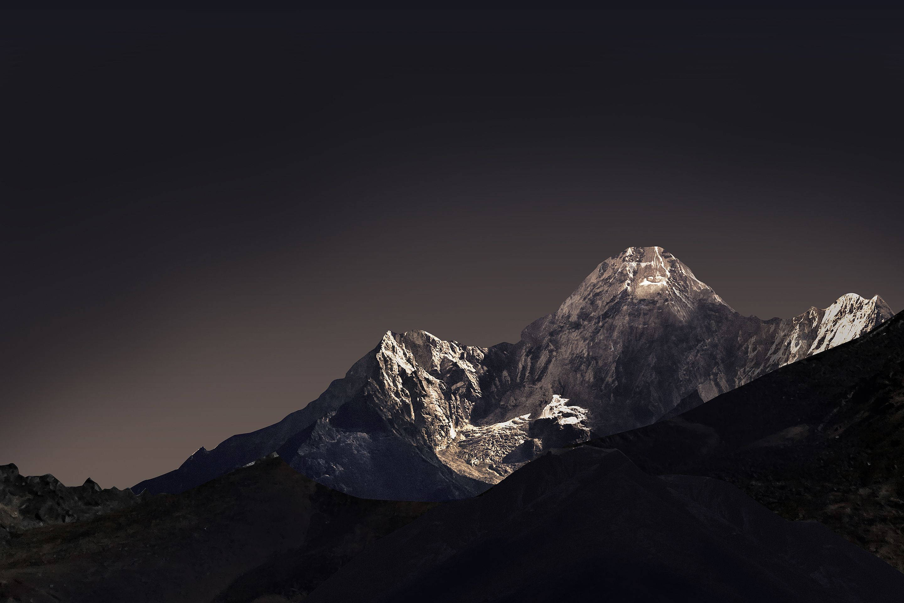 山景 桌布 壁紙 — 雄偉的雪山頂在暮色中發光，映襯著漸暗的天空。