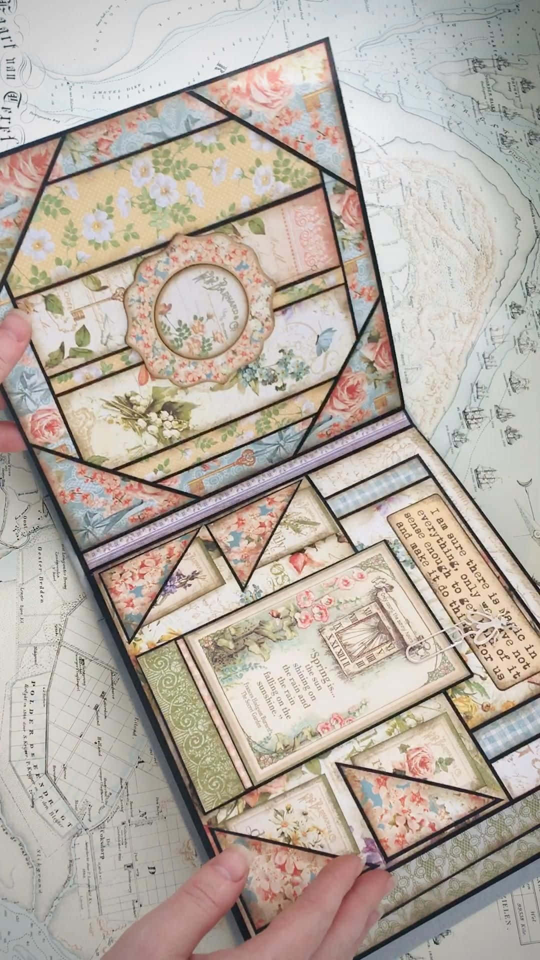 Scrapbooking 桌布 壁紙 — 雙手在地圖背景上打開一本帶有花卉圖案和古董文字的復古剪貼簿。