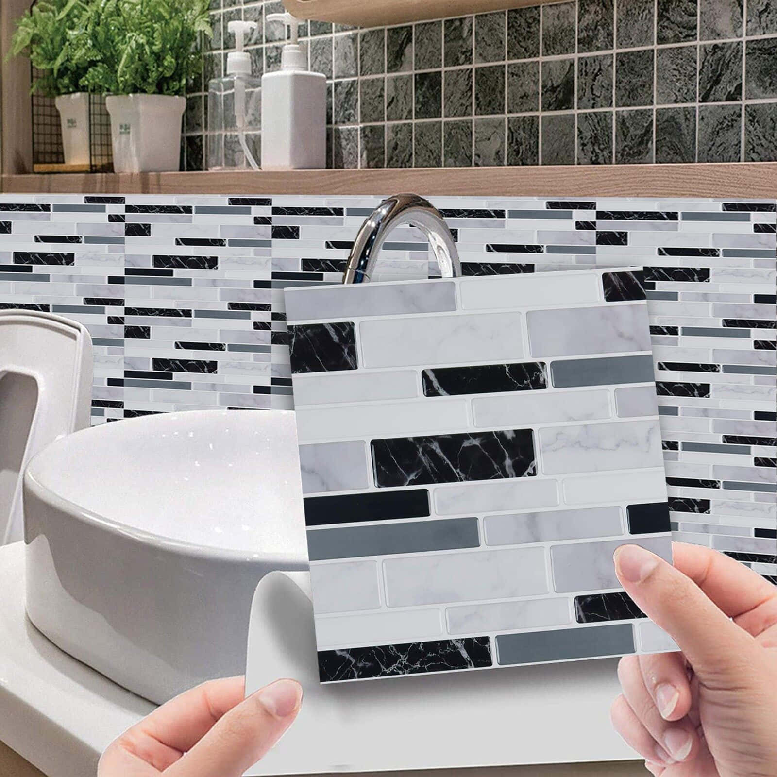 Tiles 桌布 壁紙 — 雙手在現代浴室洗手台前拿著一塊大理石紋磁磚樣本，搭配相應的防濺板。