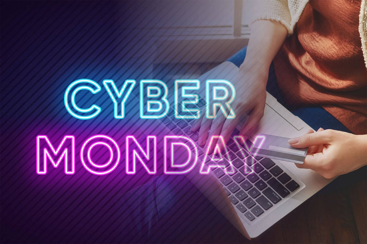 Monday 桌布 壁紙 — 雙手在發光霓虹燈 Cyber Monday 文字下打字，同時手持信用卡。