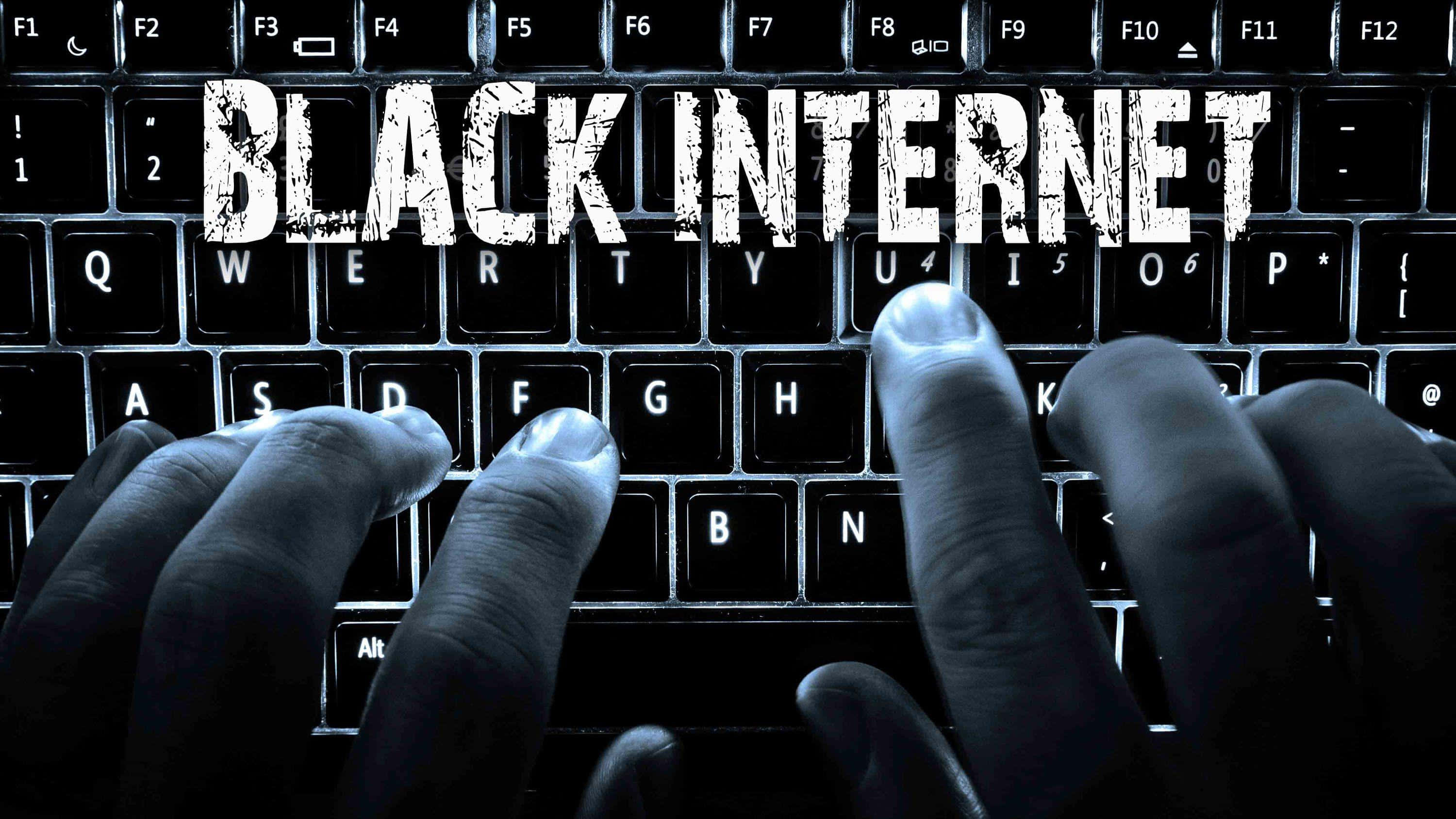 Dark Web 桌布 壁紙 — 雙手在鍵盤上打字，深色按鍵上帶有粗糙白色字體的「BLACK INTERNET」文字疊加。