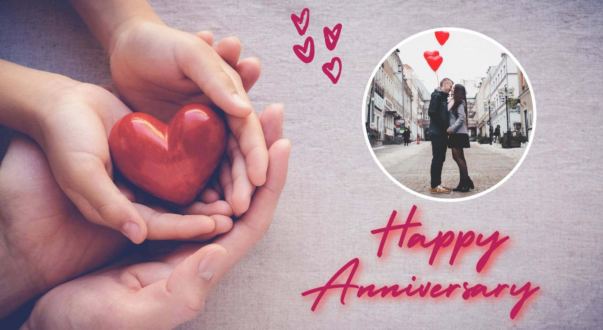 Happy Anniversary 桌布 壁紙 — 雙手捧著一個閃亮的紅色心形，圓形插圖顯示一對情侶在街上接吻，周圍有漂浮的心形和「Happy Anniversary」文字。