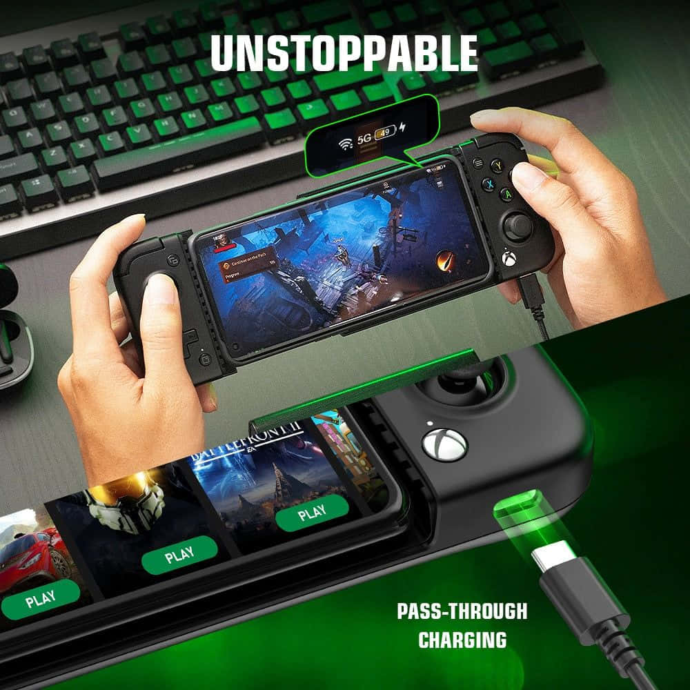 Gaming Accessories 桌布 壁紙 — 雙手握著帶有控制器配件的遊戲手機，下方是鍵盤和發出綠光的充電座。