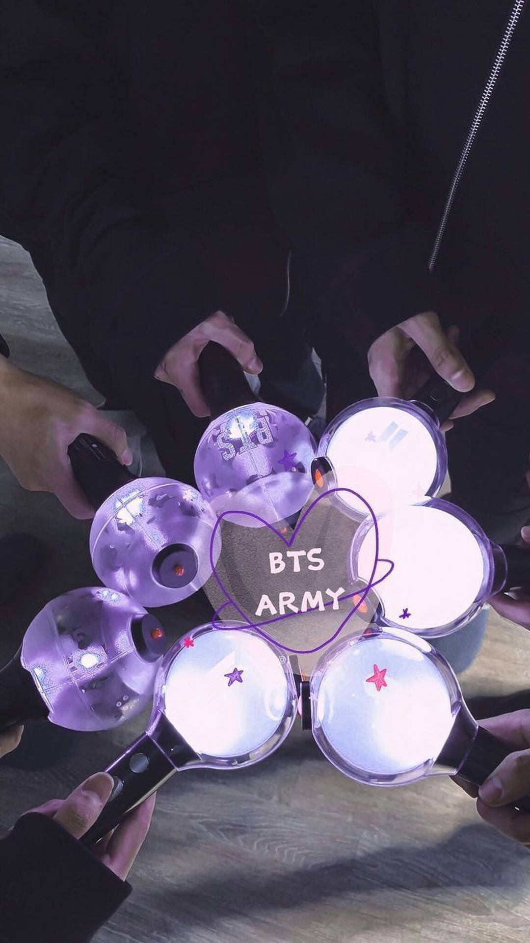 粉絲們握著發光的紫色螢光棒，排列成一個圓圈，圍繞著帶有BTS ARMY文字的心形。 — BTS ARMY GIF 壁紙