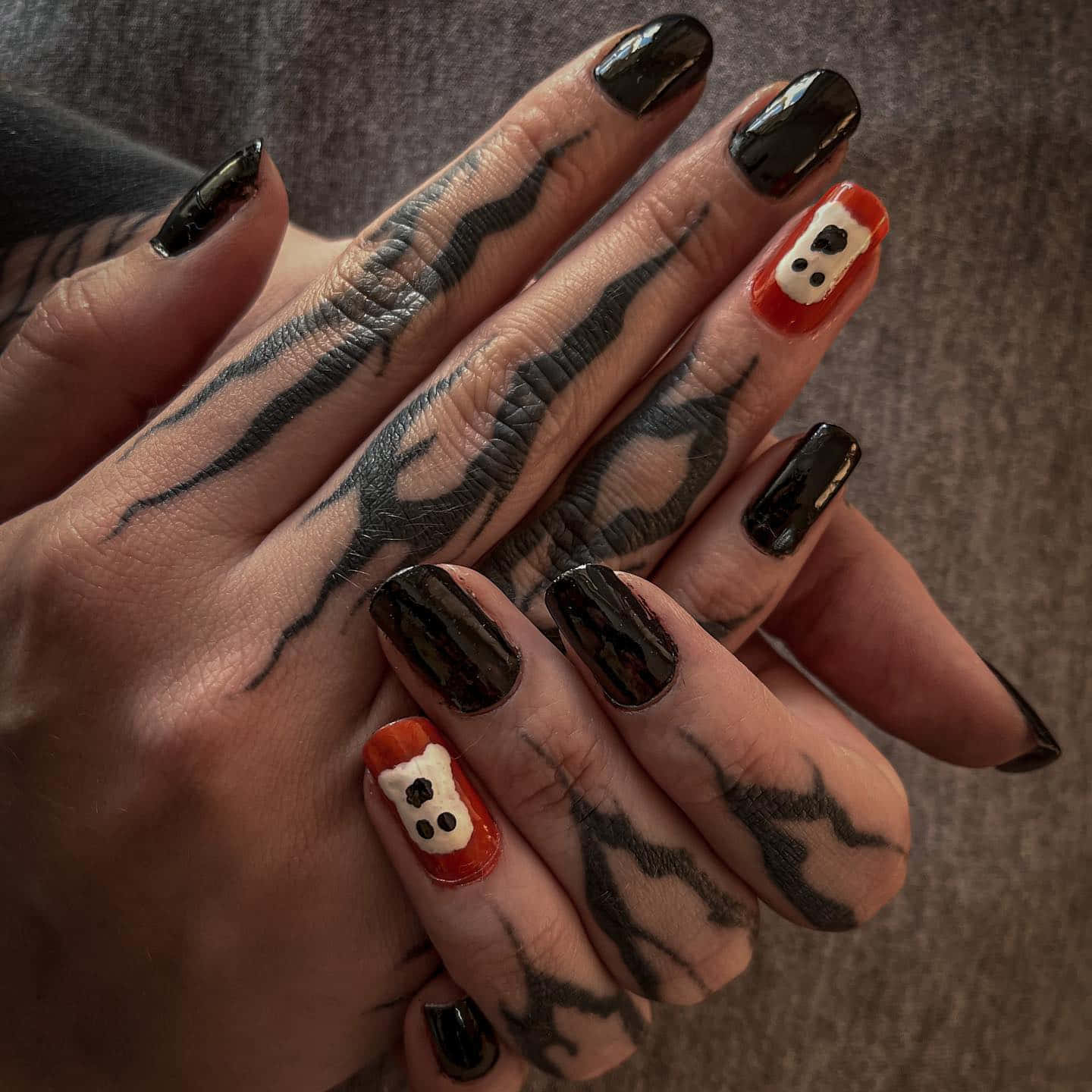 Halloween Nail Art 桌布 壁紙 — 雙手特寫，帶有黑色刺青和萬聖節主題的鬼魂指甲藝術在兩根手指上。