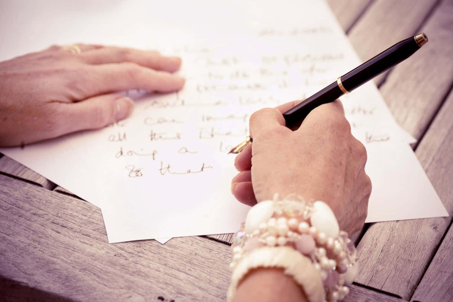 Letter 桌布 壁紙 — 雙手用筆在紙上寫一封真摯的信，紙張放在風化的木桌上，特寫鏡頭。