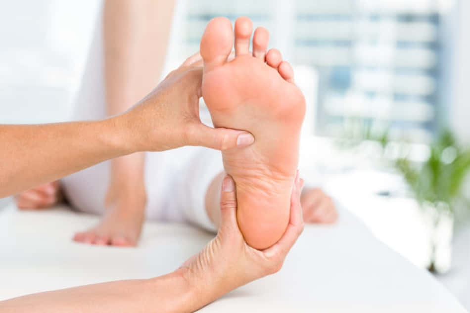 feet 桌布 壁紙 — 雙手輕柔按摩裸露腳部的特寫，背景是明亮寧靜的水療環境。