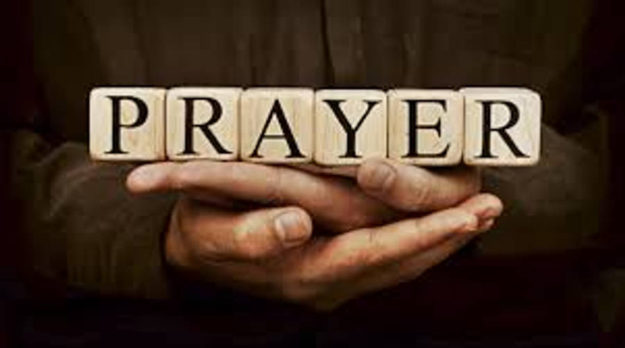 Praying Hands 桌布 壁紙 — 雙手輕輕捧著拼出「祈禱」一詞的木塊，在柔和溫暖的光線中。