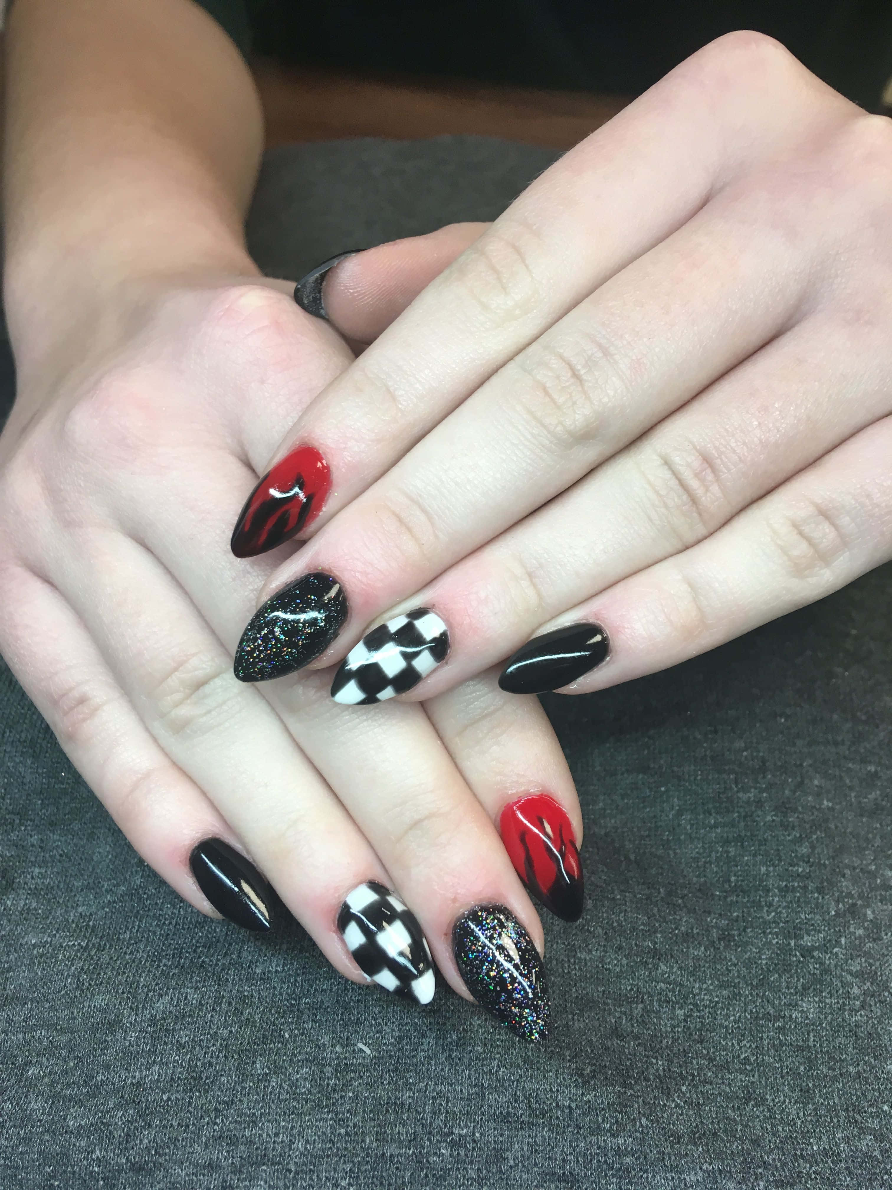Nail 桌布 壁紙 — 雙手近距離特寫，在紋理灰色布料上展現大膽的黑、紅、白格子指甲藝術。