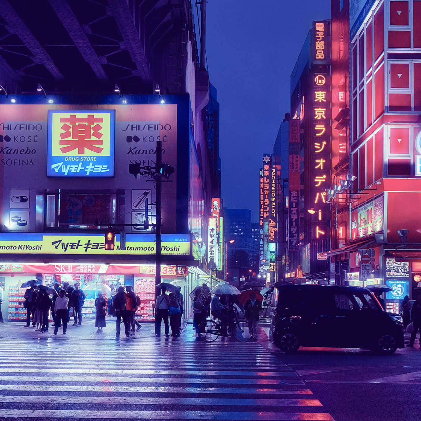 東京 桌布 壁紙 — 雨夜的東京街道，被鮮豔的霓虹燈照亮，倒映在濕漉漉的路面上，行人在閃爍的廣告牌下穿行。