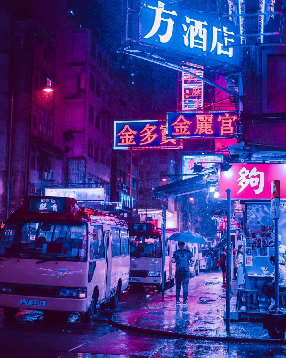 日本 桌布 壁紙 — 雨夜霓虹燈照亮的街道，發光的招牌在濕漉漉的人行道上反射，一個人撐著傘。