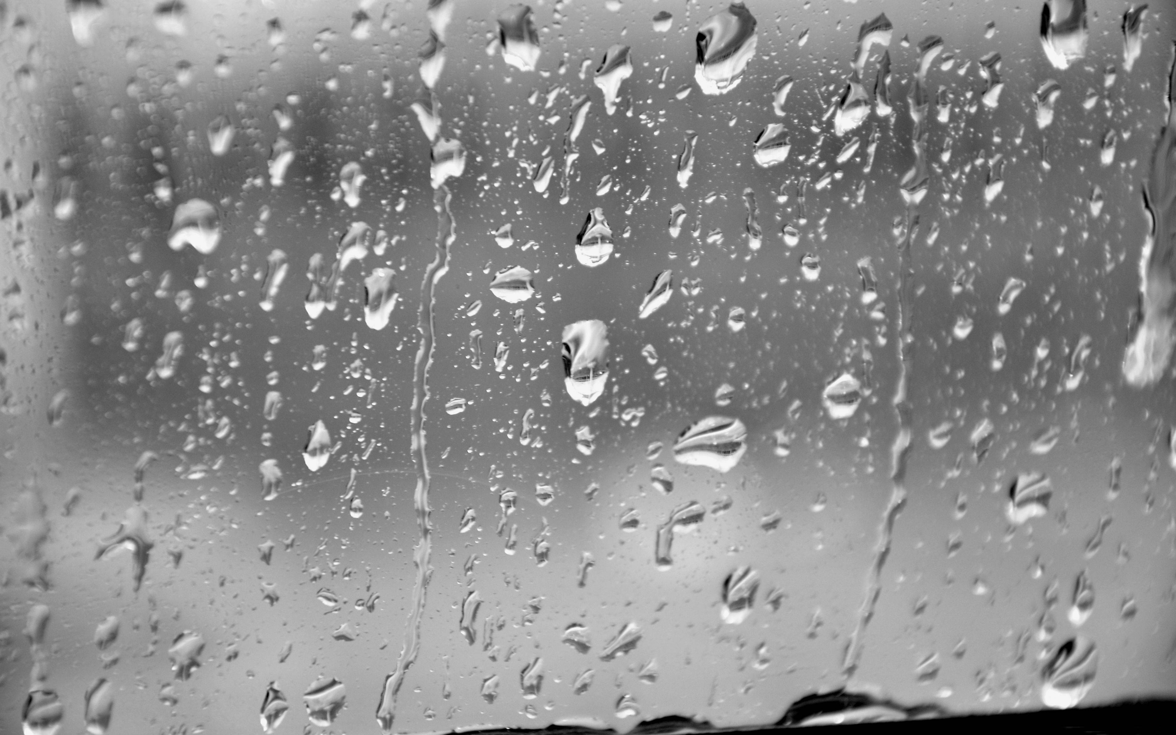 Rainy Day 桌布 壁紙 — 雨滴依附並滑落玻璃窗，單色特寫模糊了窗外的世界。
