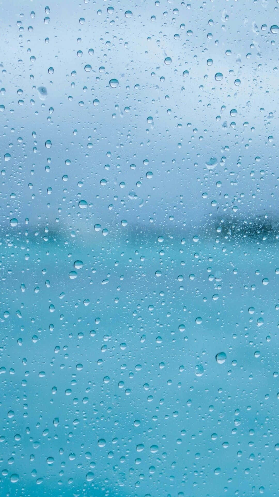 玻璃上的雨滴與模糊的藍色海洋和天空景觀 — Google pixel 壁紙