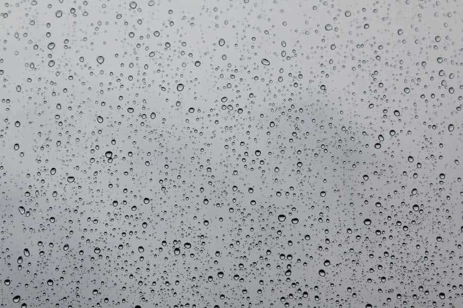 Water Texture 桌布 壁紙 — 雨滴依附在玻璃表面，以柔和的灰色天空為背景，營造出柔和模糊的背景。