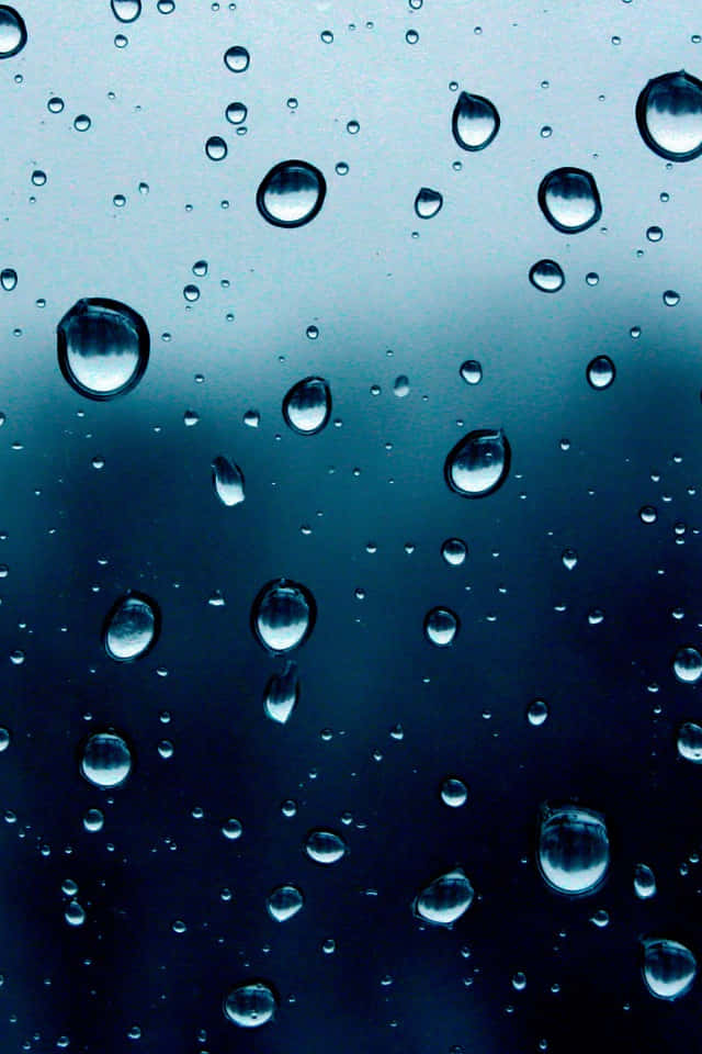 iOS 4 桌布 壁紙 — 雨滴依附在玻璃表面，反射出憂鬱的藍色漸變天空。