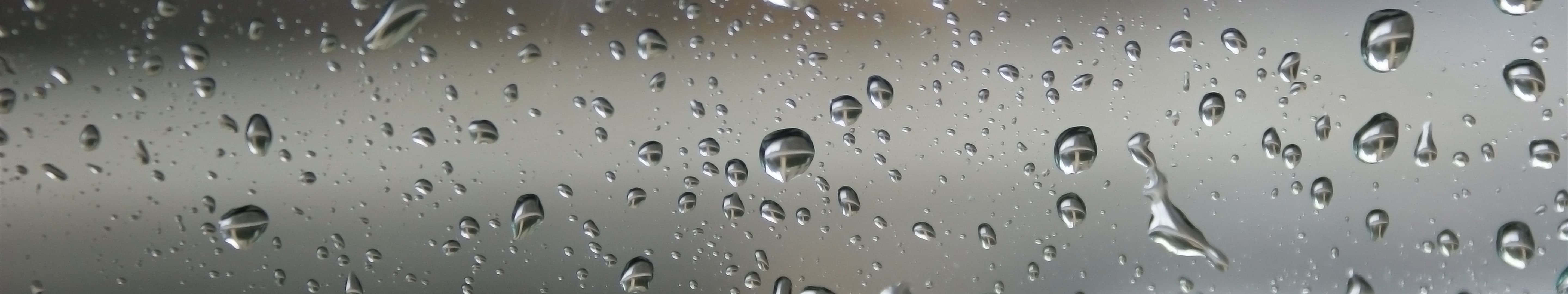 5760x1080 桌布 壁紙 — 雨滴依附在玻璃表面，反射出暗淡的灰色天空，特寫視角。