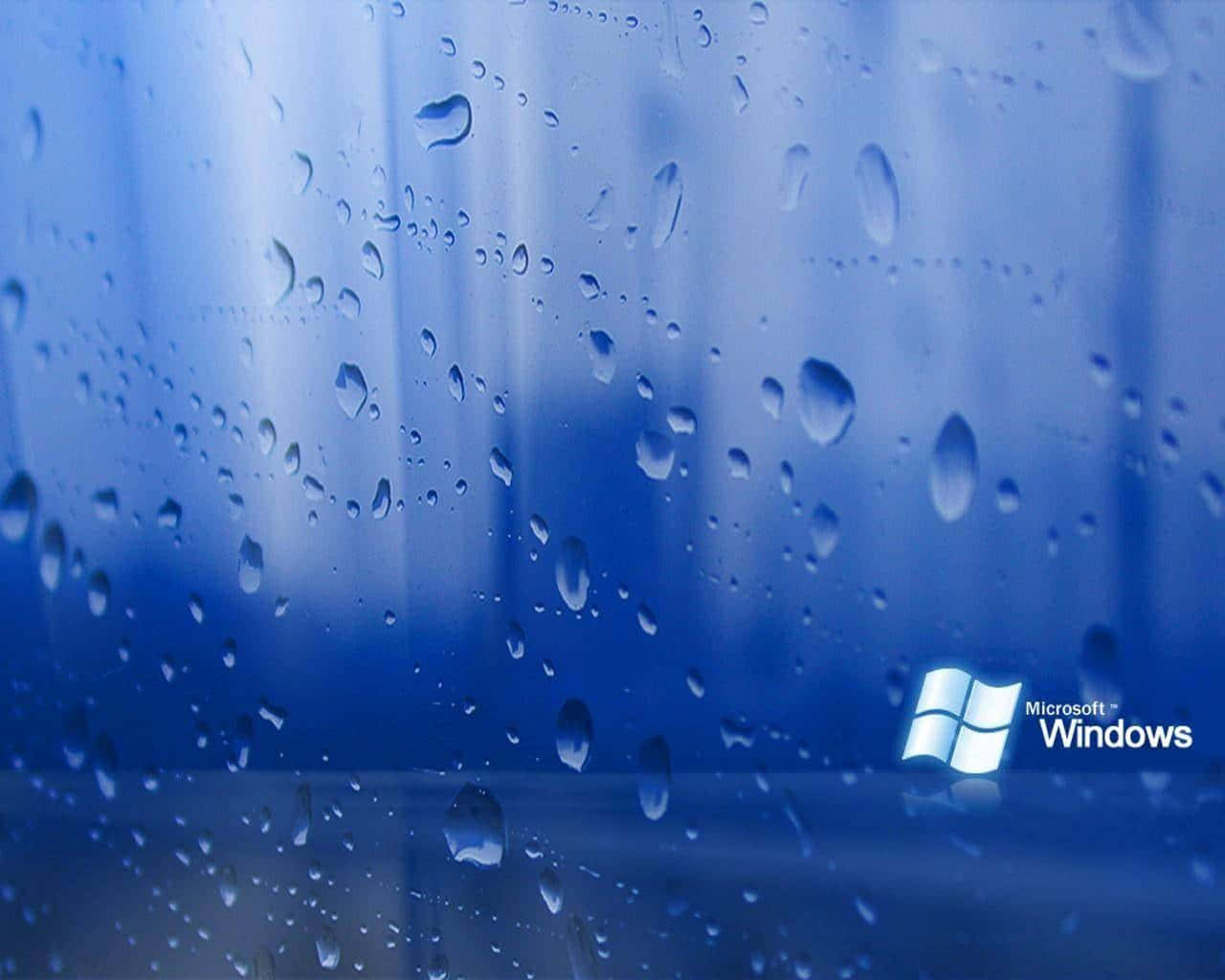Windows 98 桌布 壁紙 — 雨滴依附在玻璃表面，反射出柔和的藍光，角落有 Microsoft Windows 標誌。
