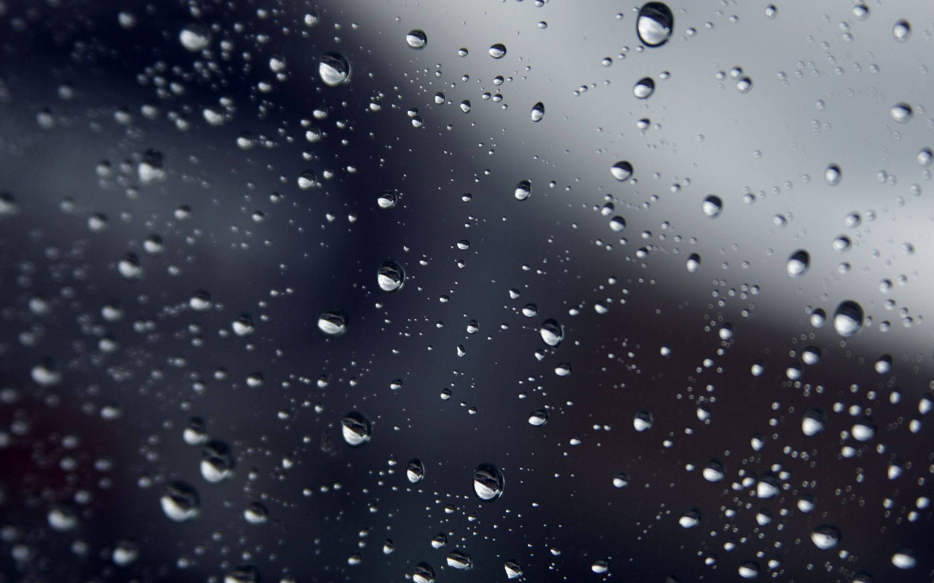 Rainy Day 桌布 壁紙 — 雨滴依附在玻璃表面，將柔和的灰色背景模糊成柔軟的抽象形狀。