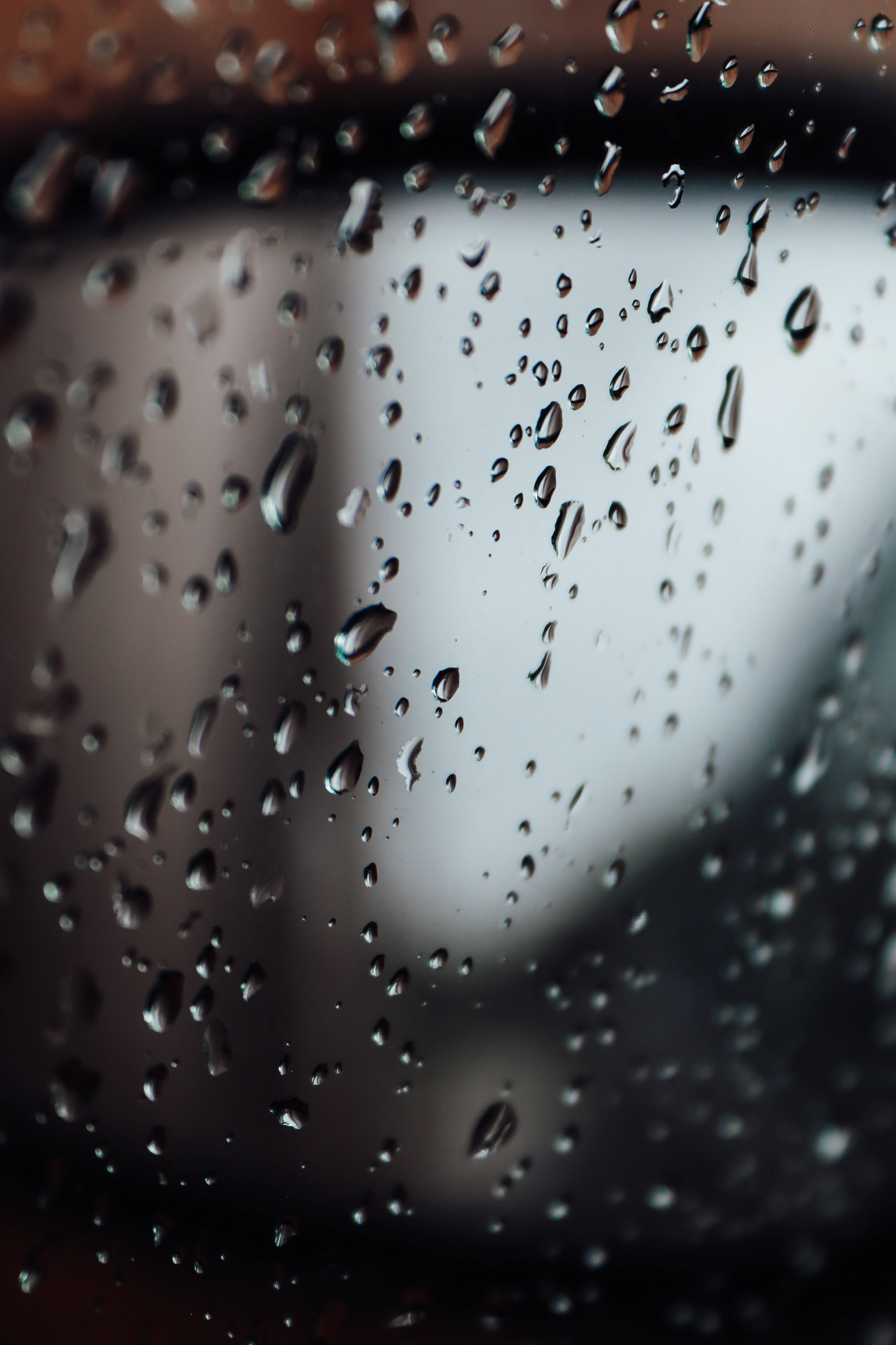Transparent 桌布 壁紙 — 雨滴依附在玻璃表面，將柔和的灰色背景模糊成抽象形狀。